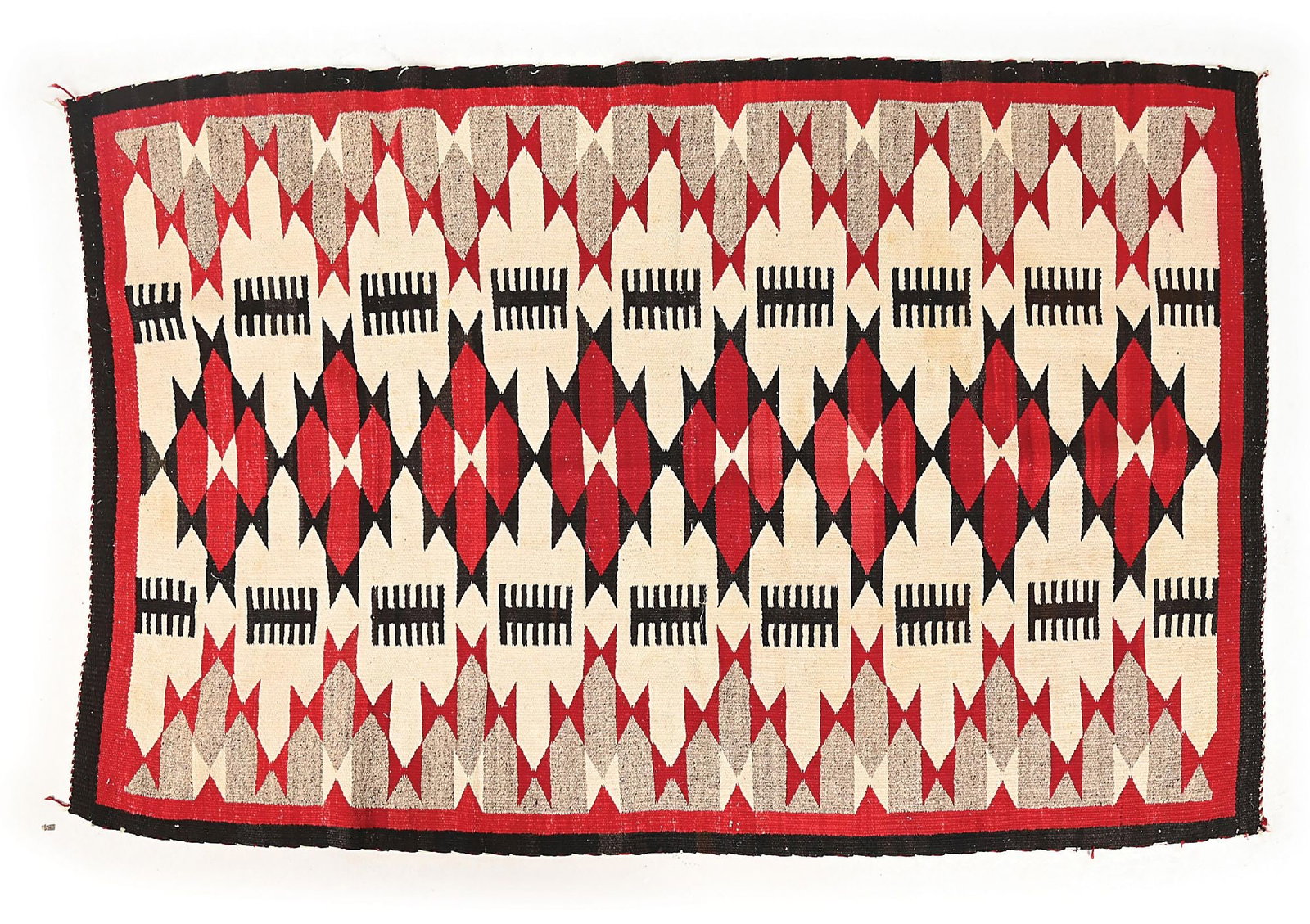 NAVAJO (DINÉ) WEAVING: Circa 1920. With a central vertical row of serrated diamonds, flanked on each side by serrated triangles, each encompassing hourglass forms. Dimensions: 68" x 42" Colors: white, red, black, grey Condi