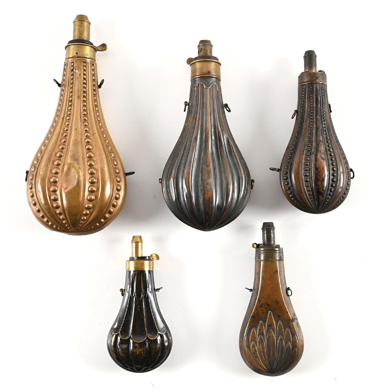 LOT OF 5: LARGE POWDER FLASKS.: Most have a European flair with geometric embossed and convex designs with no figures. Sizes range from about 6" to 9 1/4". The largest is stamped JAMES DIXON & SONS. The next largest is stamped AM FL