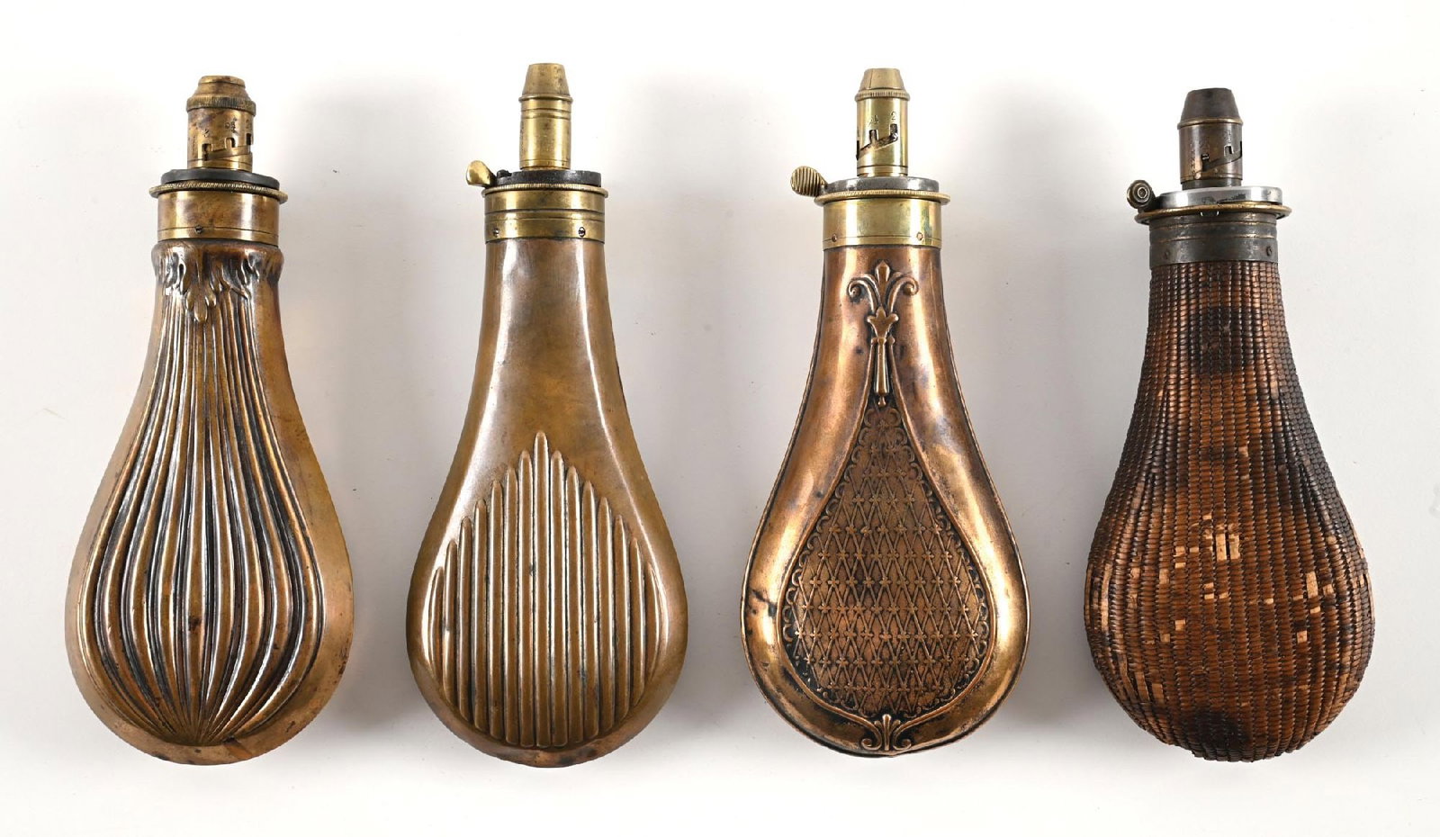 LOT OF 4: MID 19TH CENTURY SHEFFIELD FLUTED BRASS POWDER FLASKS.: All are large size and each is English maker marked. The first example is marked Bartram & Co. (Riling #934). It measures about 6 7/8" and sports a flued dual side body. Nicely patinaed with just some