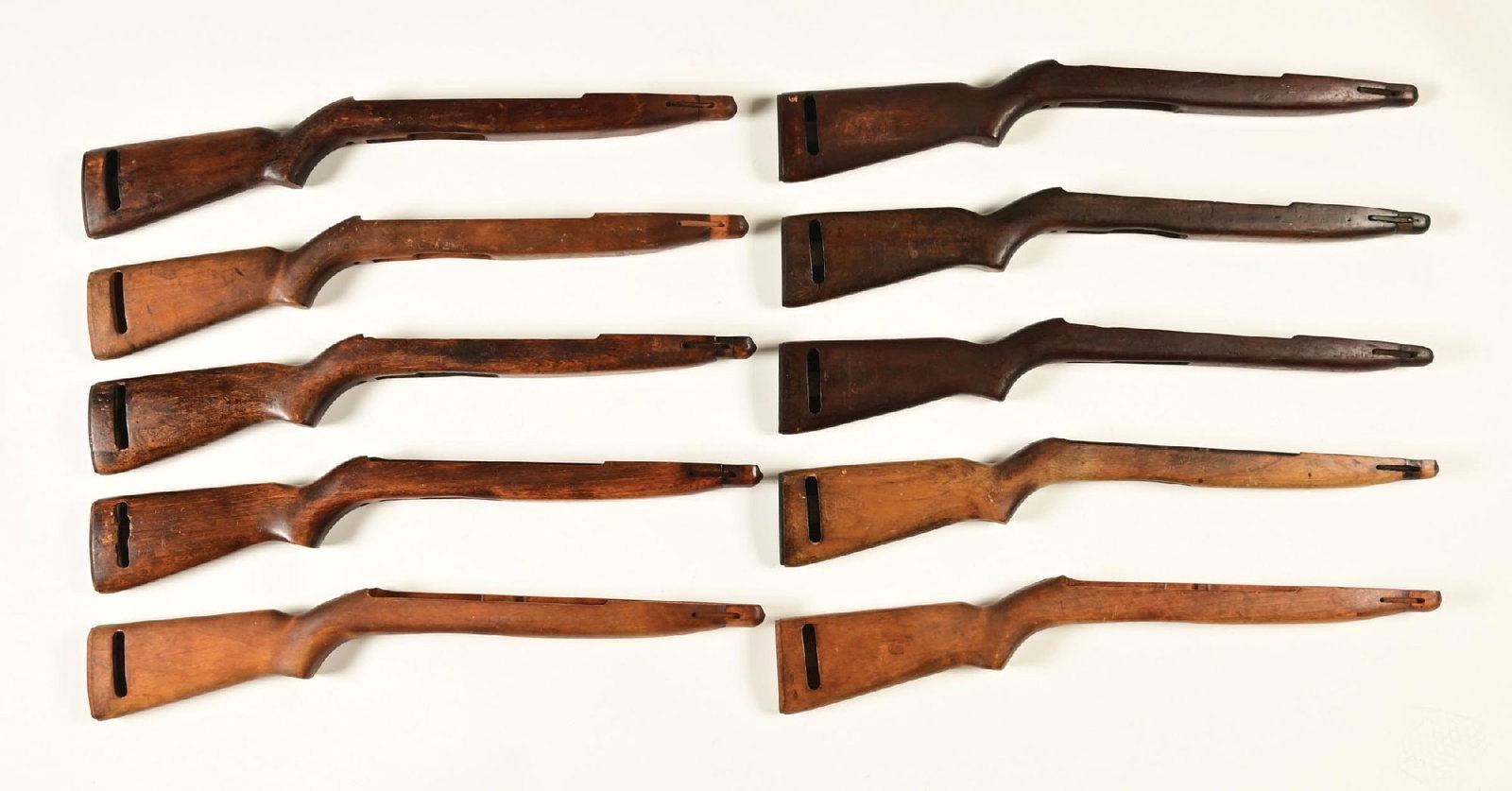 LOT OF 10: M1/M2 CARBINE STOCKS.: Lot includes 10 various M1/M2 carbine pot belly walnut and beech stocks with M2 switch cuts. One has an Italian "FAT" cartouche, while another has West German Bundeswehr inspection markings in the sli