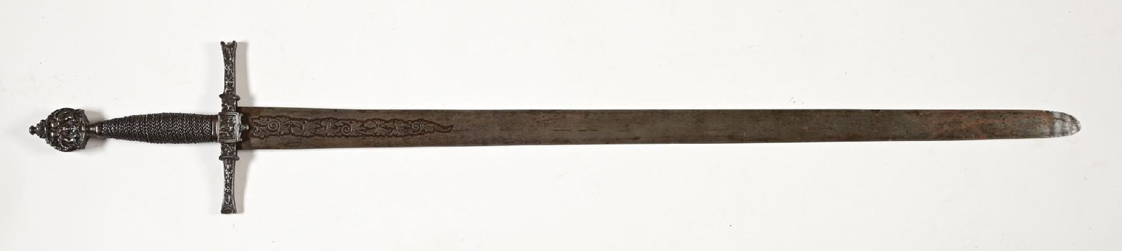 ETCHED LONGSWORD WITH ELABORATE CAST GUARD.: Probably Victorian. Unsharpened blade with wide tip, acid etched with designs of floral scroll at ricasso. Cast crossguard and pommel with indistinct figures, crossguard appears to be central
