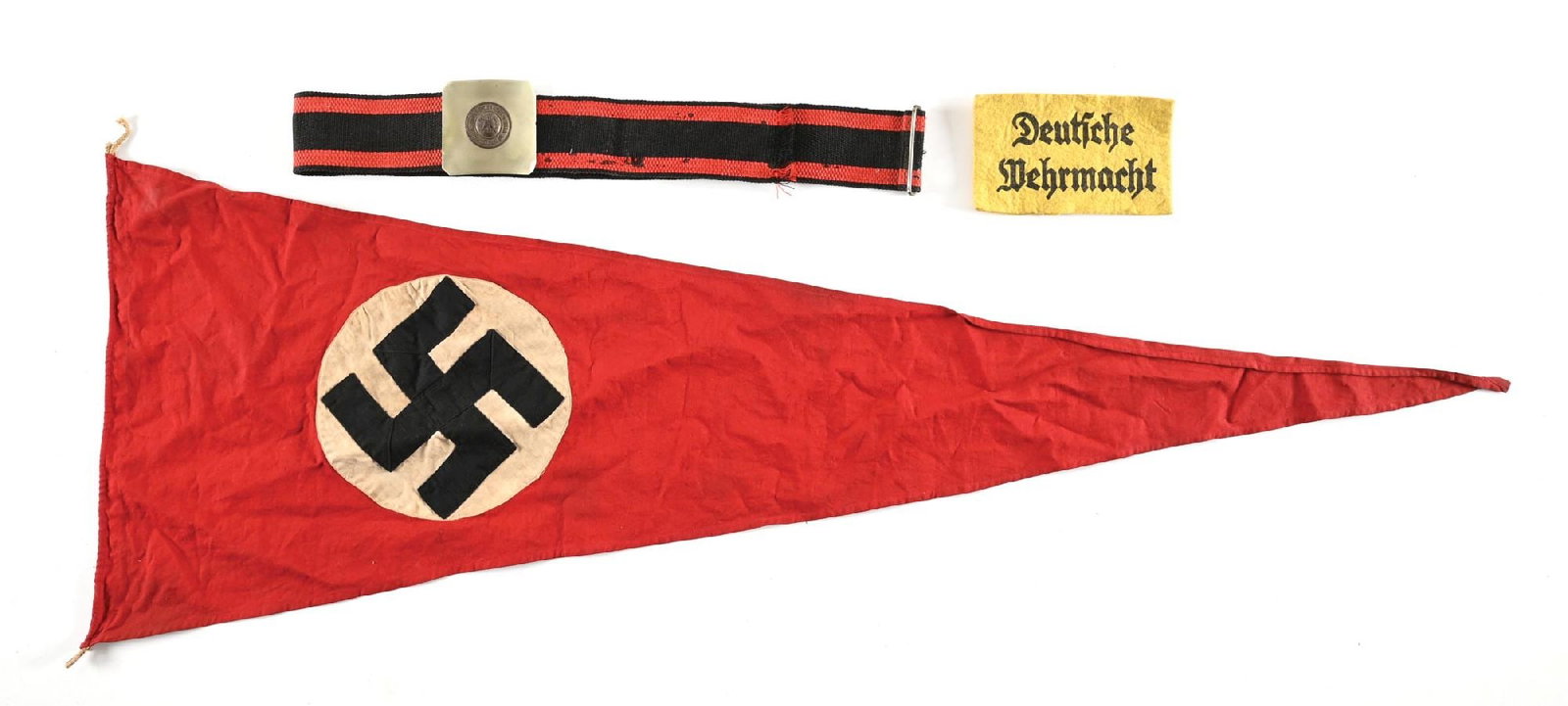 THIRD REICH PENNANT, ARMBAND, AND BELT.: Lot contains a double-sided NSDAP pennant measuring 43" by 15" with light staining throughout with no visible damage, a "Deutsche Wehrmacht" armband with heavy staining, and a German (exact period