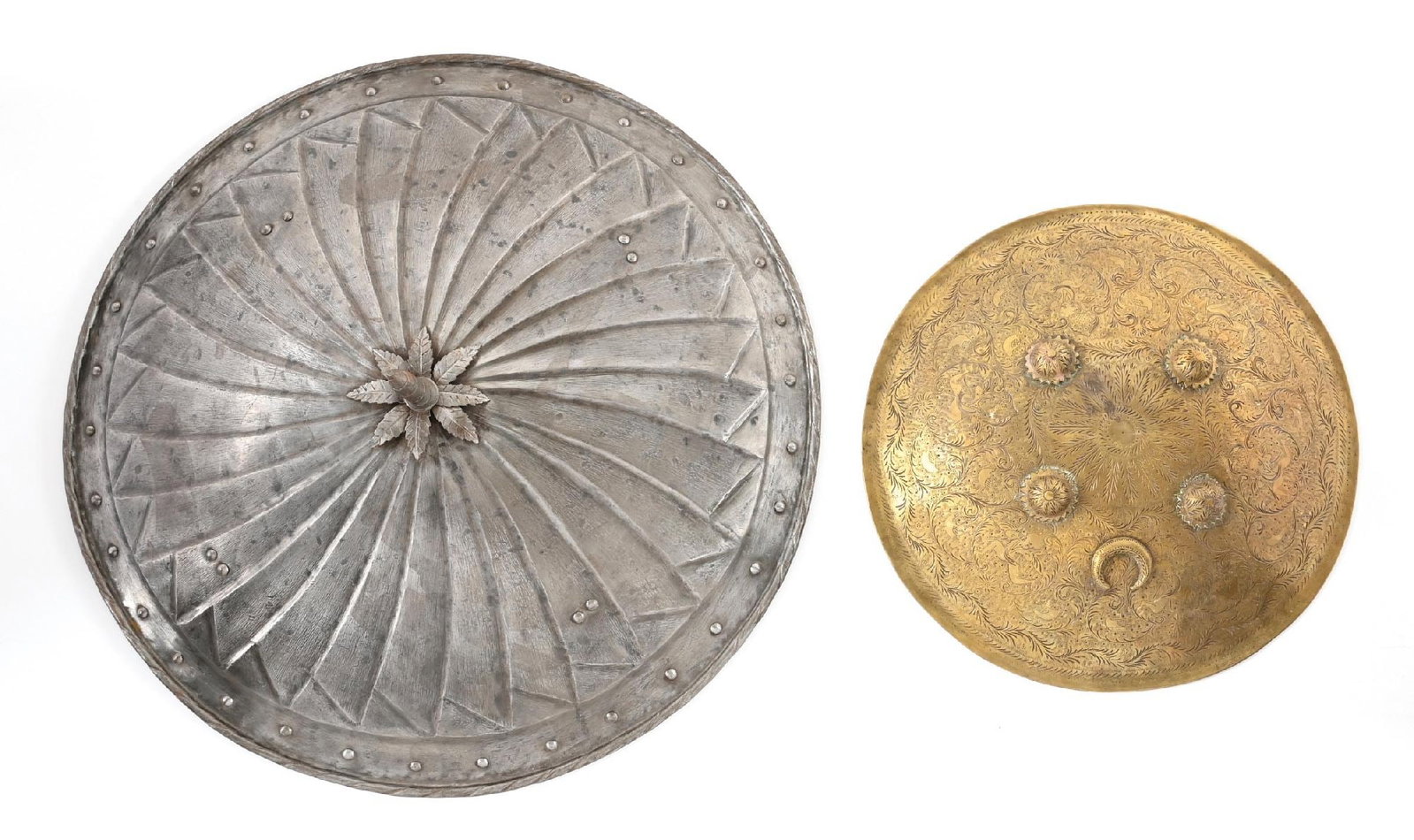 LOT OF 2: DECORATIVE SHIELDS.: Lot consists of (A) Shield with spiral fluting, a central spike on a floral boss, and a rolled rim with rosettes about the perimeter and four pairs of bosses on the body. CONDITION: Essentially a