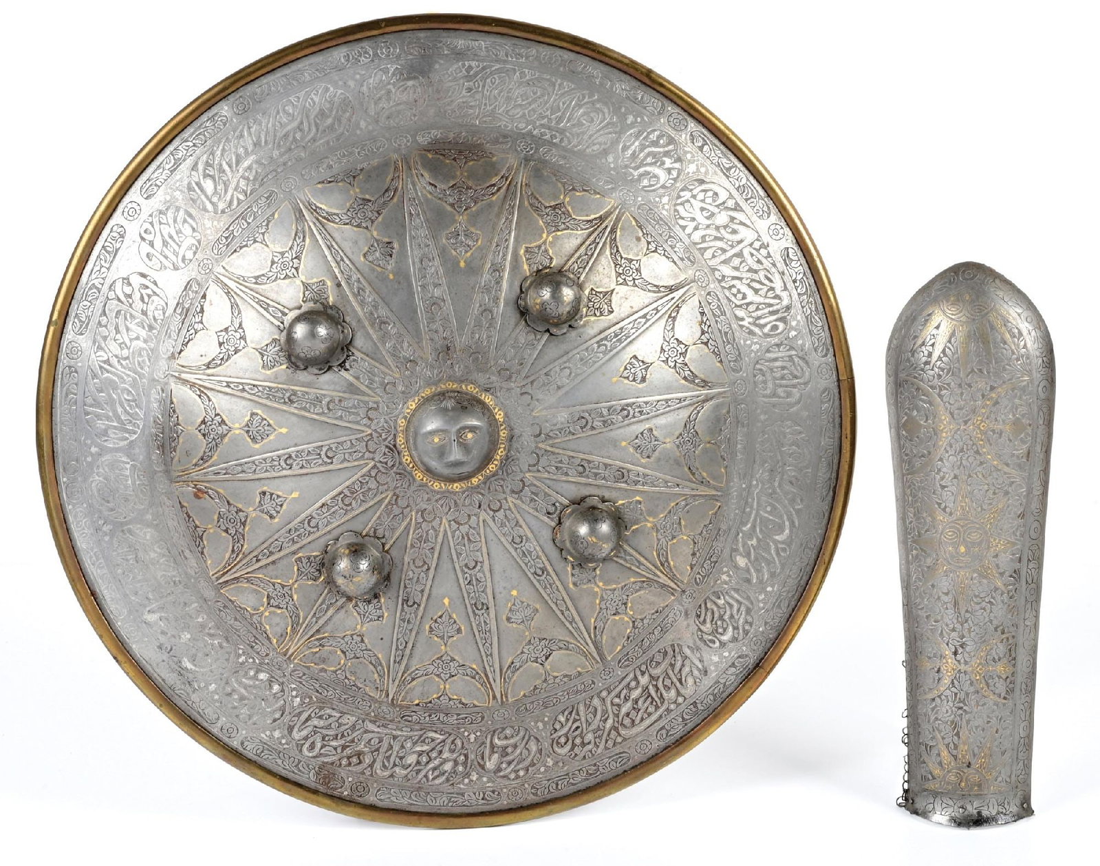 LOT OF 2: PERSIAN SIPAR SHIELD AND BAZUBAND ARM GUARD.: Lot consists of (A) Classic Sipar shield with silver accented calligraphy work about the rim with 16-sided ray motif about a central boss in the form of a face, with floral work in the rays, Islamic