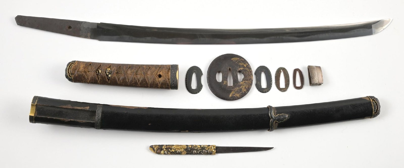 UBU MUMEI WAKIZASHI WITH WAVE THEMED KOSHIRAE: Probably Echizen Seki. Approximately 44.9cm. 29mm motohaba, 7mm kasane. Classic shinogi zukuri form with itame jigane. Gunome choji hamon with areas of almost togari and tobiyaki. Midare boshi that ru