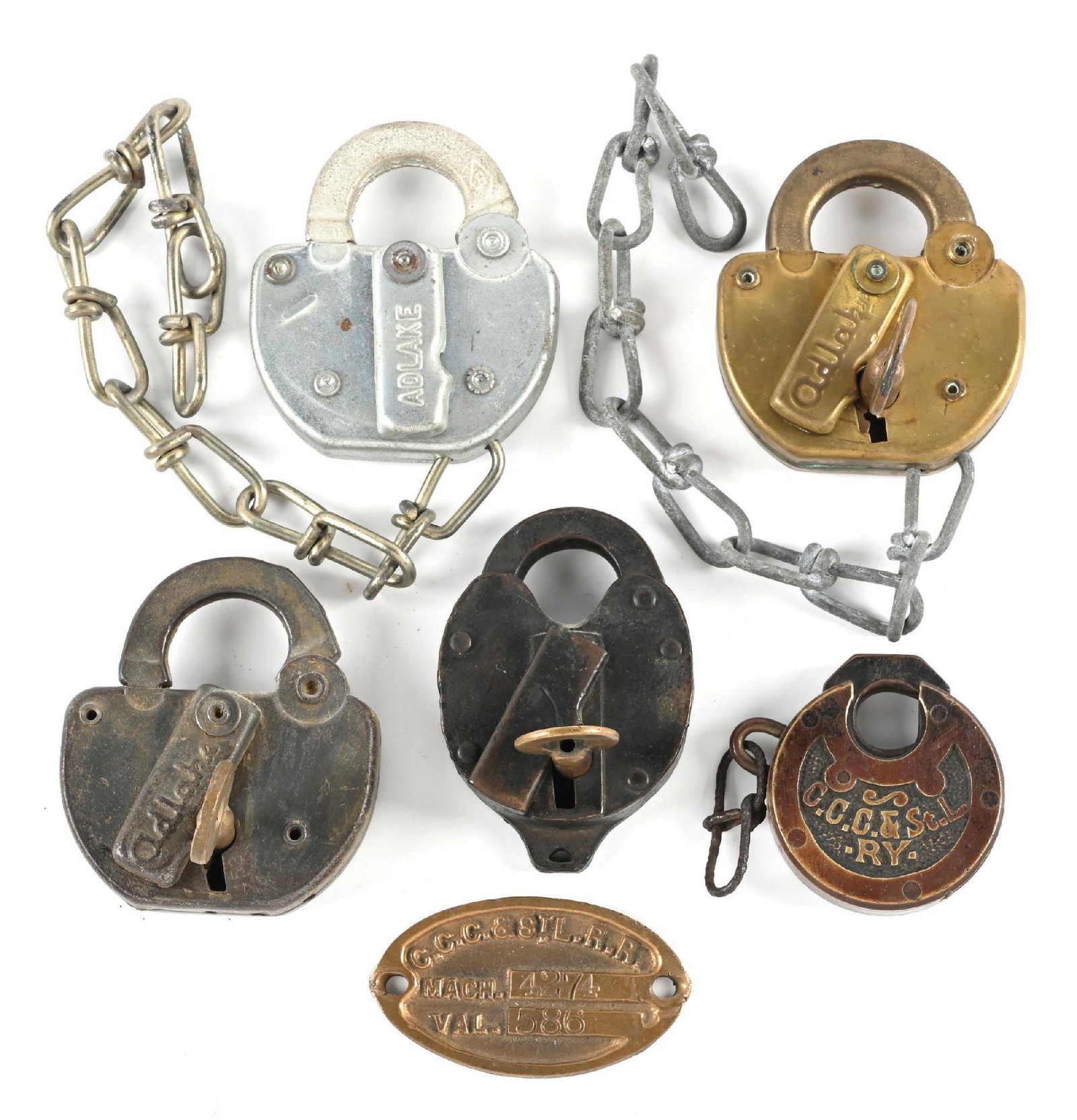 LOT OF 6: RAILROAD LOCKS & MISC.: (A) A steel Adlake switch lock, incised “PC 76” on the back face. Dust cover spring functions properly. A seven-link chain is attached. The lock is in new, unused condition. (B) A bronze