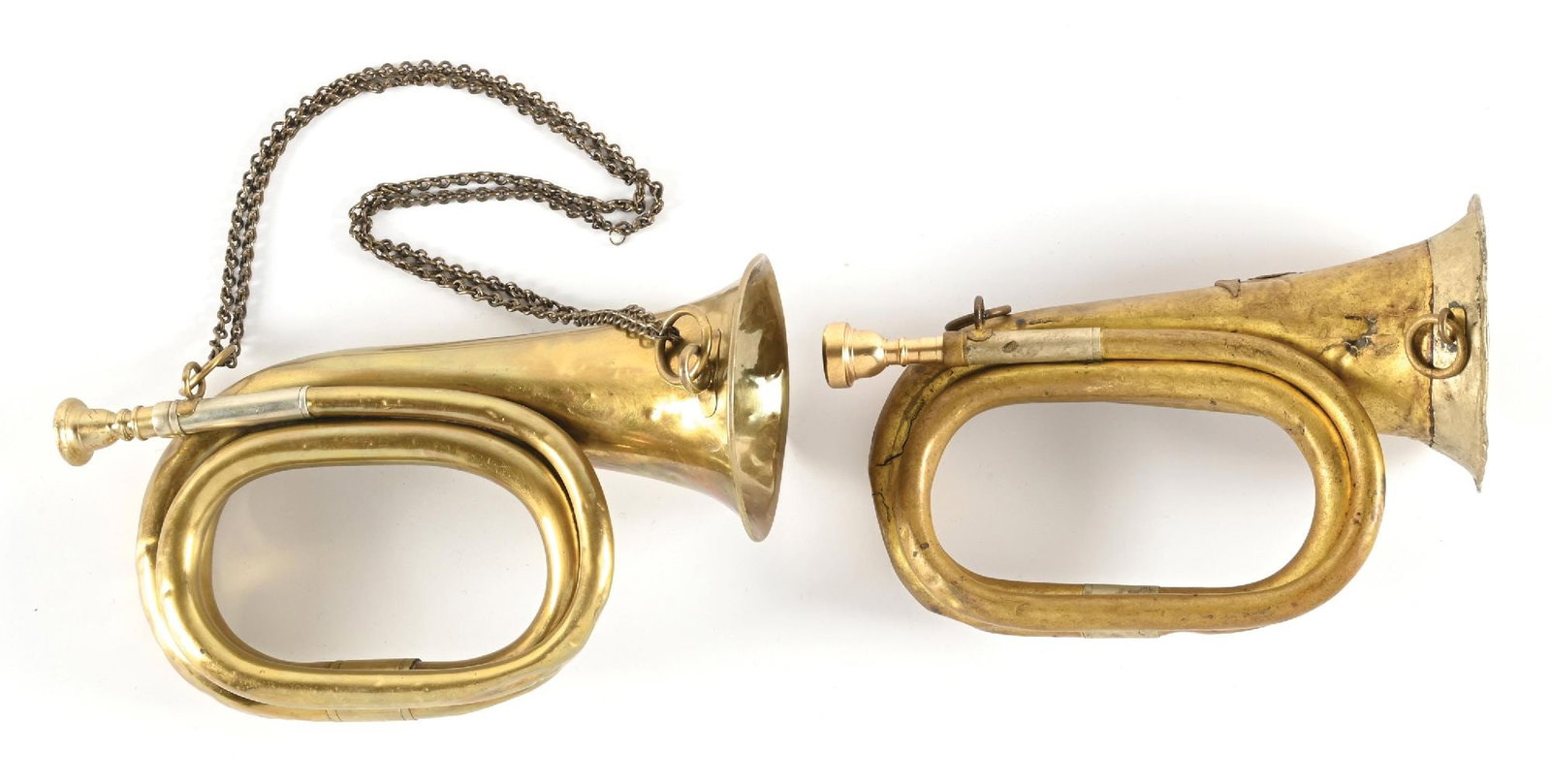 LOT OF 2: THIRD REICH BUGLES.: Lot contains: (A) "C.W. Moritz. Berlin" bugle with chain and mouthpiece. Bugle has light to heavy dents throughout with a 1 inch crack. (B) Third Reich SA bugle with SA eagle. Bugle exhibits heavy