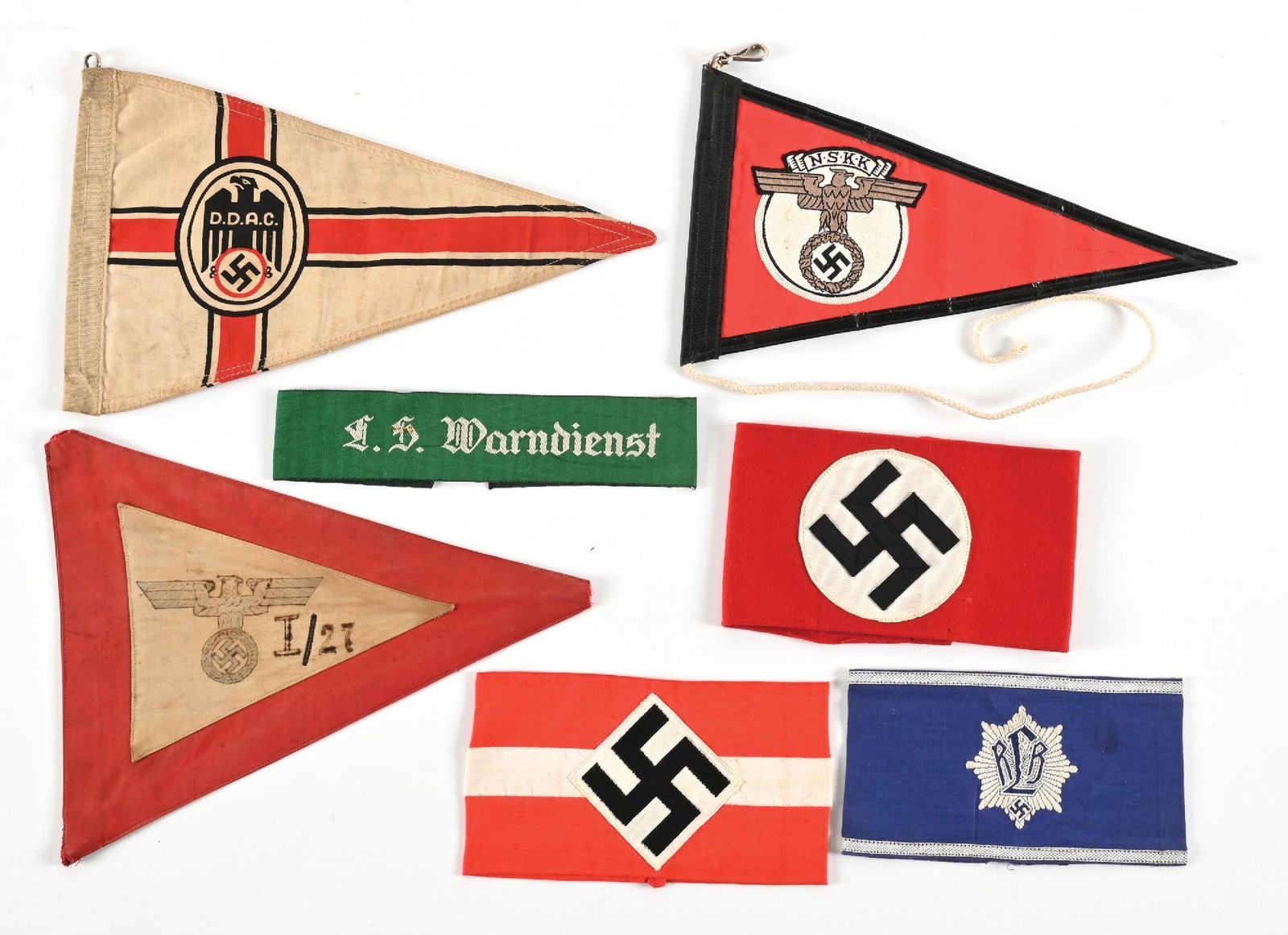 LOT OF 7: GERMAN WWII ARMBANDS AND PENNANTS.: Lot of 7 Third Reich armbands and pennants. Lot includes an unissued "LS Warndienst" (Air Raid Warning) armband with a couple of light stains, NSDAP armband with several moth nips, moth tracking, and 