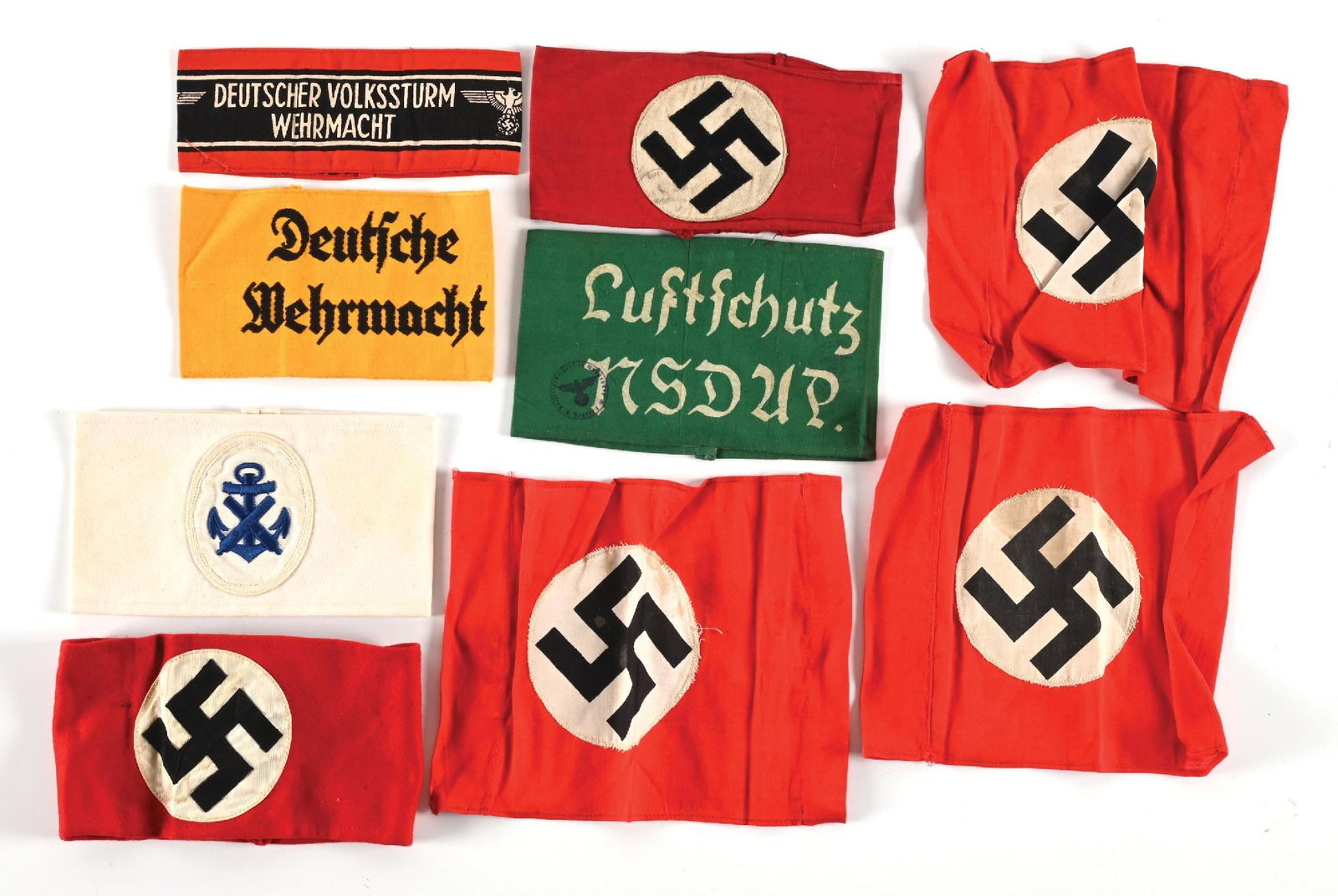 LOT OF THIRD REICH ARMBANDS.: Lot of Third Reich armbands. Lot includes several NSDAP armbands (one with a partial RZM tag remaining) as well as Volksturm, Wehrmacht, Luftschutz, and Kriegsmarine examples. CONDITION: Overall very 