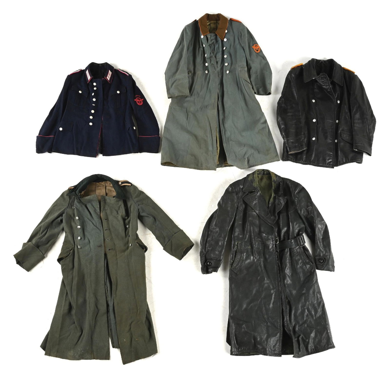 LOT OF 5: GERMAN WWII TUNICS AND OVERCOATS.: Lot contains: (A) Third Reich "Schutzpolizei" NCO tunic in a dark blue wool exhibiting very light wear and staining throughout and no visible damage. Carmine color piping on the cuffs, collar, and fro