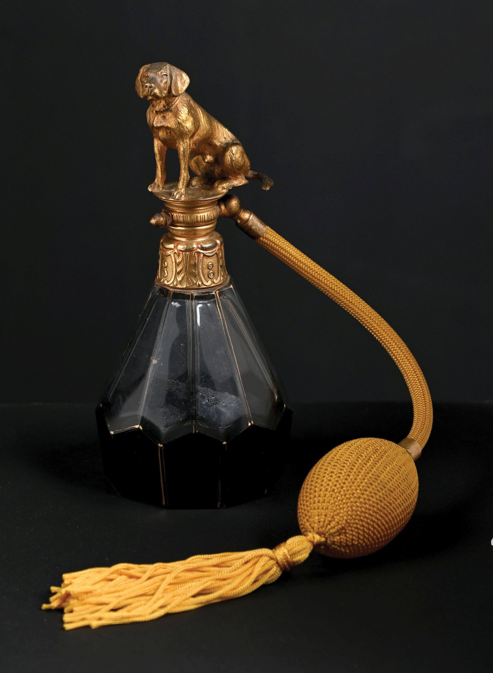 ANGEL OLIVERAS GUART LAB TOPPED PERFUME WITH ATOMIZER: C. 1920. Exquisite Angel Oliveras Guart French Art Deco perfume bottle, made of glass, black gilt, and mercury-gilt bronze, decorated at the top with the figure of a dog. The perfume is in great condi