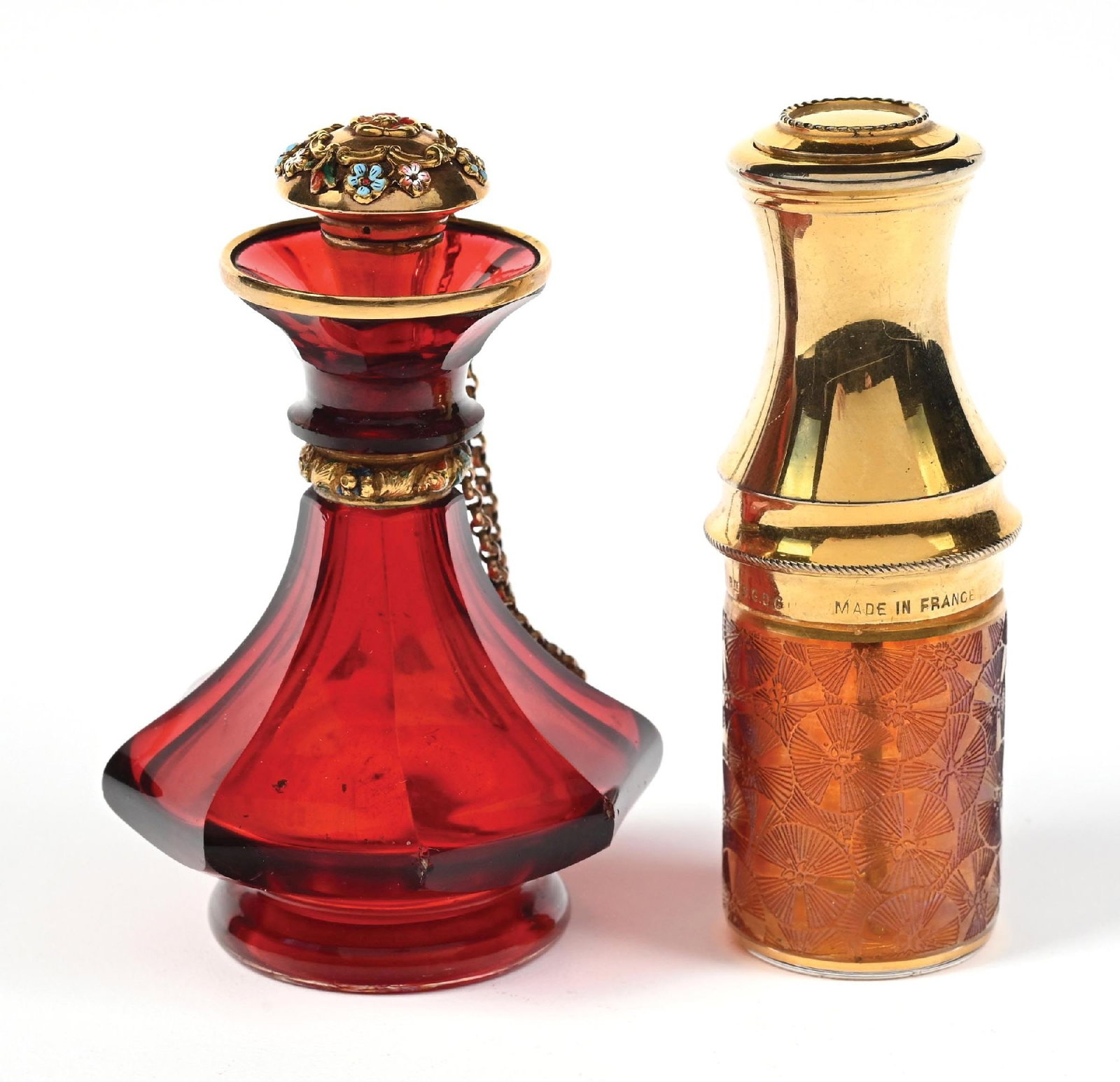 LOT OF 2: BOHEMIAN RUBY RED PERFUME BOTTLE & RED ART DECO PERFUME PUMP: C. 1900s. (A) A stunning ruby red glass perfume with a faceted geometric body that widens toward the base with ornate gold-toned accents, particularly around the neck and stopper, both of which featur