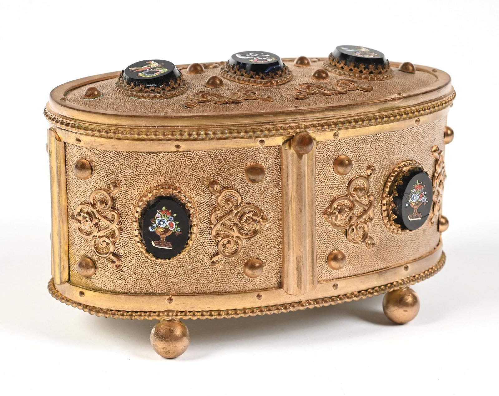 FRENCH GILDED PERFUME CASKET FEATURING PORCELAIN ENAMEL PANELS: C. 1800s. A beautiful French brass perfume vanity casket, featuring ornate brass work, a hinged lid, and inset black glass medallions with hand-painted floral and bird motifs sitting on four circular 