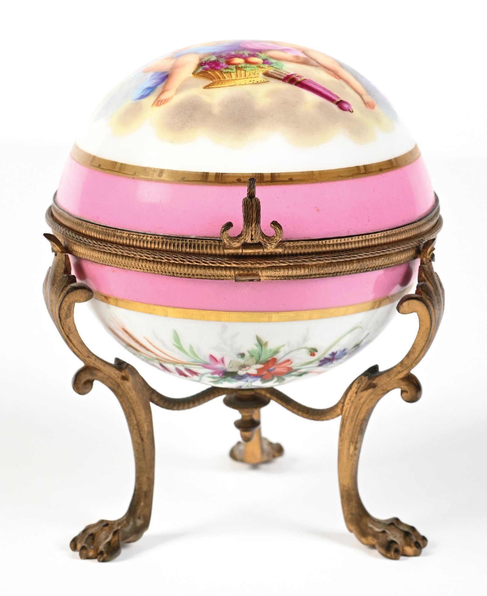 PORCELAIN CASKET PERFUME CADDY WITH CHERUB MOTIFS INCLUDING 4 PERFUMES: C. 1800s-1900s. A lovely French perfume vanity box. The round porcelain casket features two cherubs in a sea of clouds, with floral motifs at the bottom and a bright pink band. The hinged porcelain li