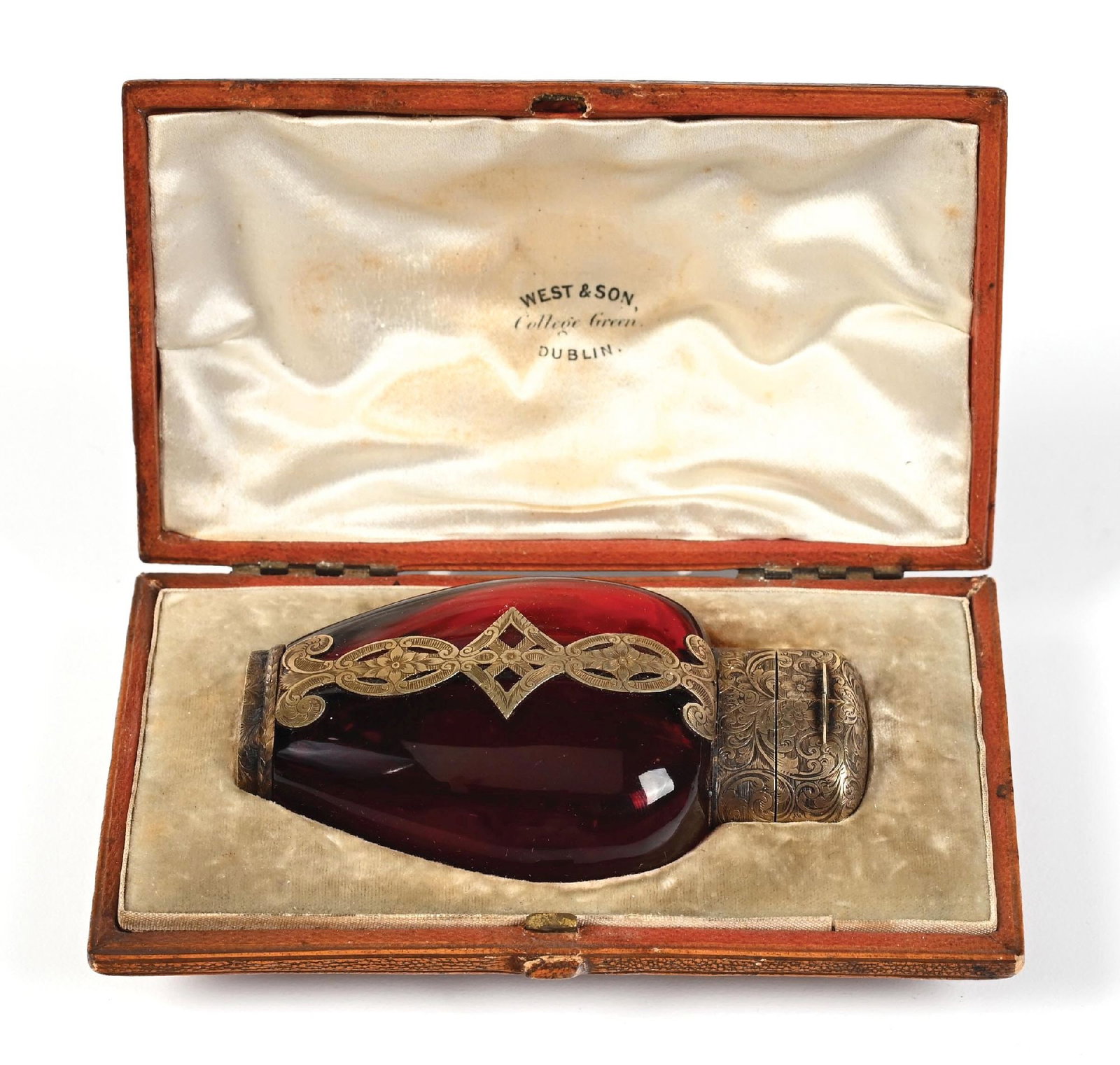 CRANBERRY GLASS WITH SILVER OVERLAY PERFUME BOTTLE IN WEST & SON, DUBLIN CASE: C. 1800s. A fantastic, original box West & Son College Green Dublin ruby-red glass dual perfume bottle stamped on the base (S. MORDAN & CO. REG D SEPE 1.1858). The perfume has intricate floral and dec