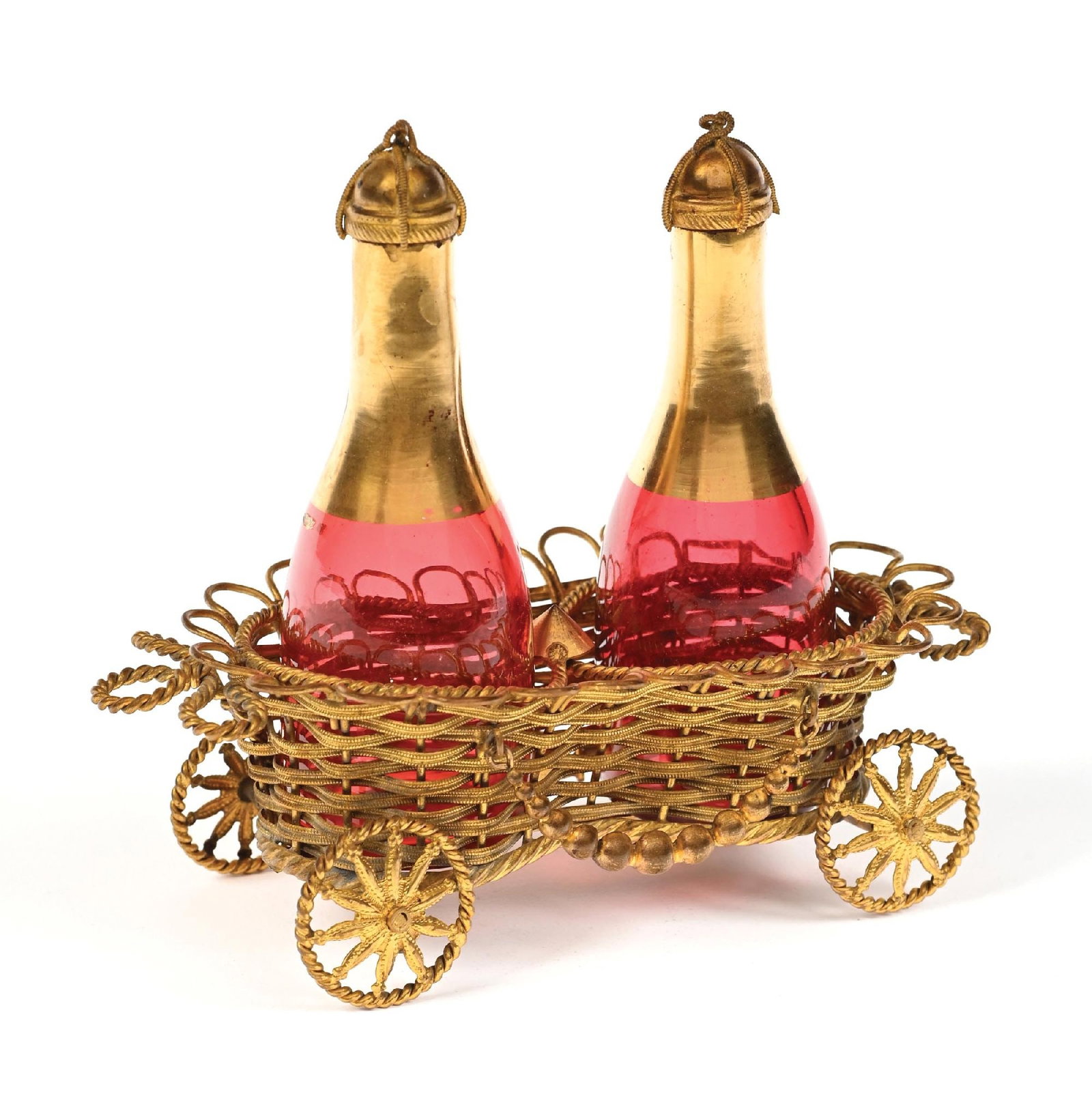 CRANBERRY CHAMPAGNE PERFUMES IN GOLD WIRE CARRIAGE: C. 1800s. A stunning, ornate, functional wheel-based perfume caddy including two red glass bottles in the shape of champagne bottles with gold bands around their necks and ornate gold-toned caps sitti
