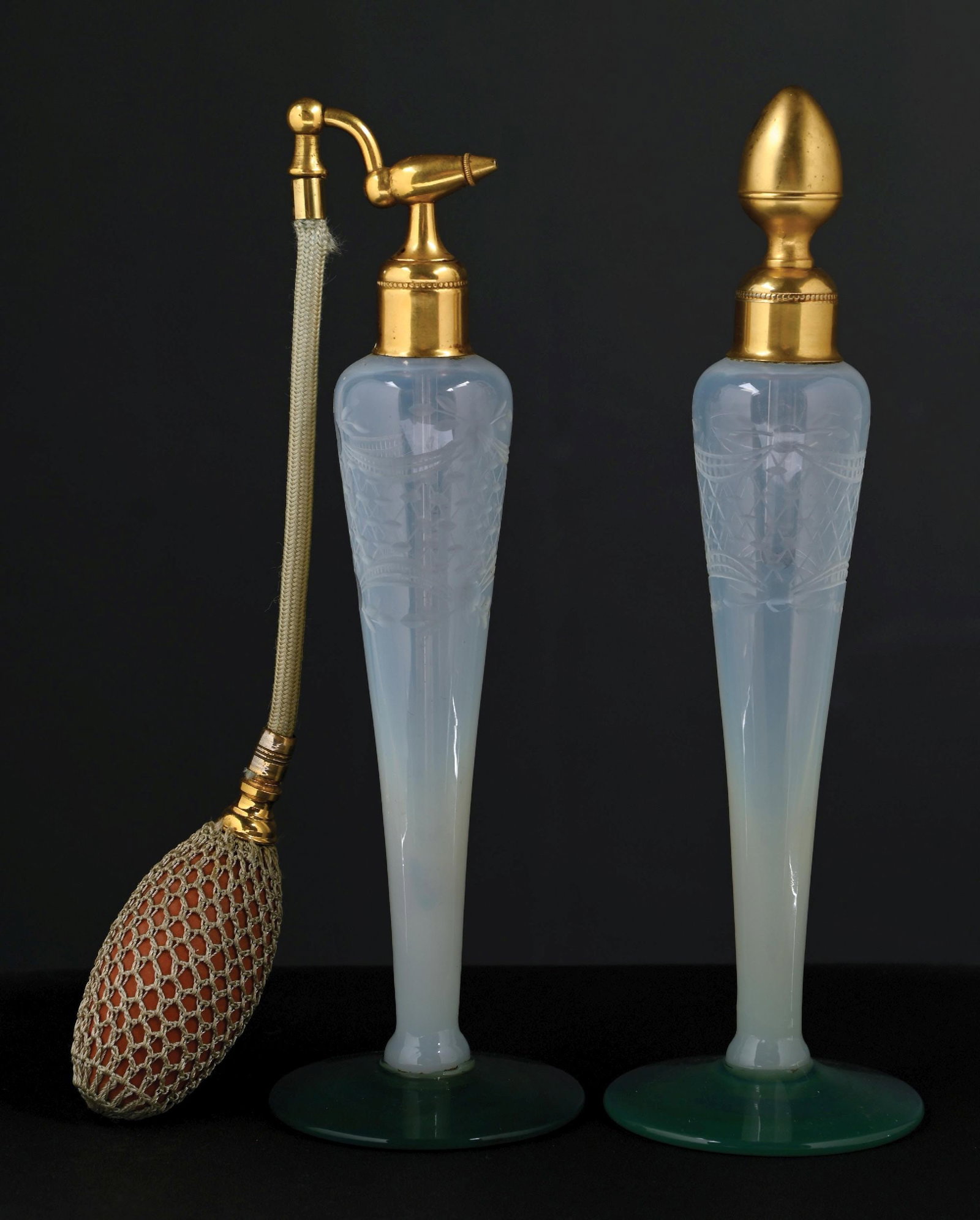 LOT OF 2: DEVILBISS FRY FOVAL PERFUMES WITH OPALESCENT WHITE GLASS ETCHED WITH DECORATIVE PATTERN: C. 1922. A spectacular pair of DeVilbiss Fry Foval perfume atomizers that feature wheel-etched opalescent bodies with jade-green feet, embossed gold hardware, and a functional one-netted light-green t