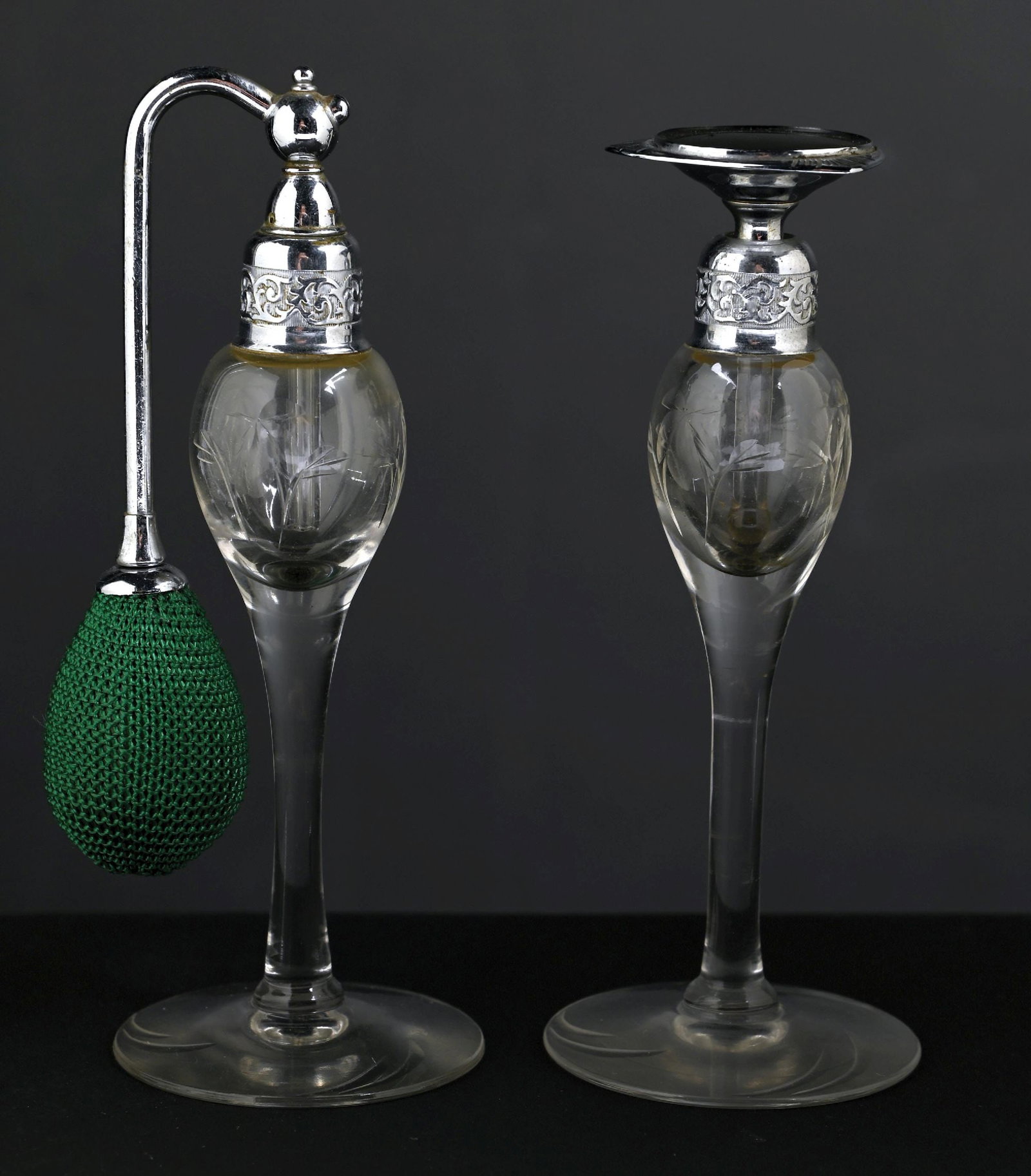 LOT OF 2: DEVILBISS DELICATE ETCHED ROCK CRYSTAL CLEAR & SILVER PERFUMES: C. 1920s. A great pair of DeVilbiss perfume atomizers; the clear glass bottles feature foliage etchings on the body, with chrome-colored hardware. The atomizers feature a fully intact dip tube and a f