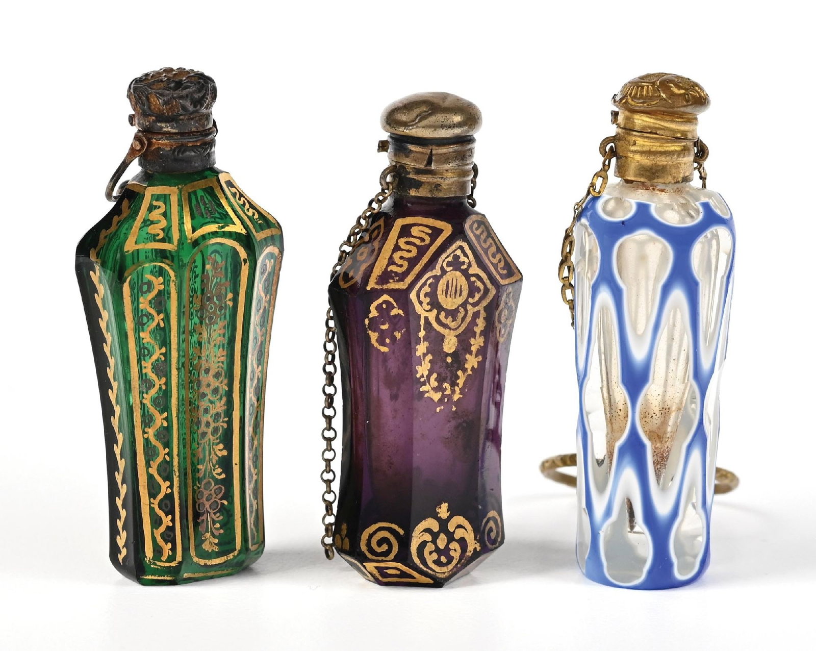 LOT OF 3: ANTIQUE ENAMELED TINY PERFUME BOTTLES: C. 1800s. Three lovely Châtelaine perfume bottles, two of which feature a gold-gild enameling with floral and scrollwork patterning, and one cut-to-clear perfume with intricate windows. The perfu