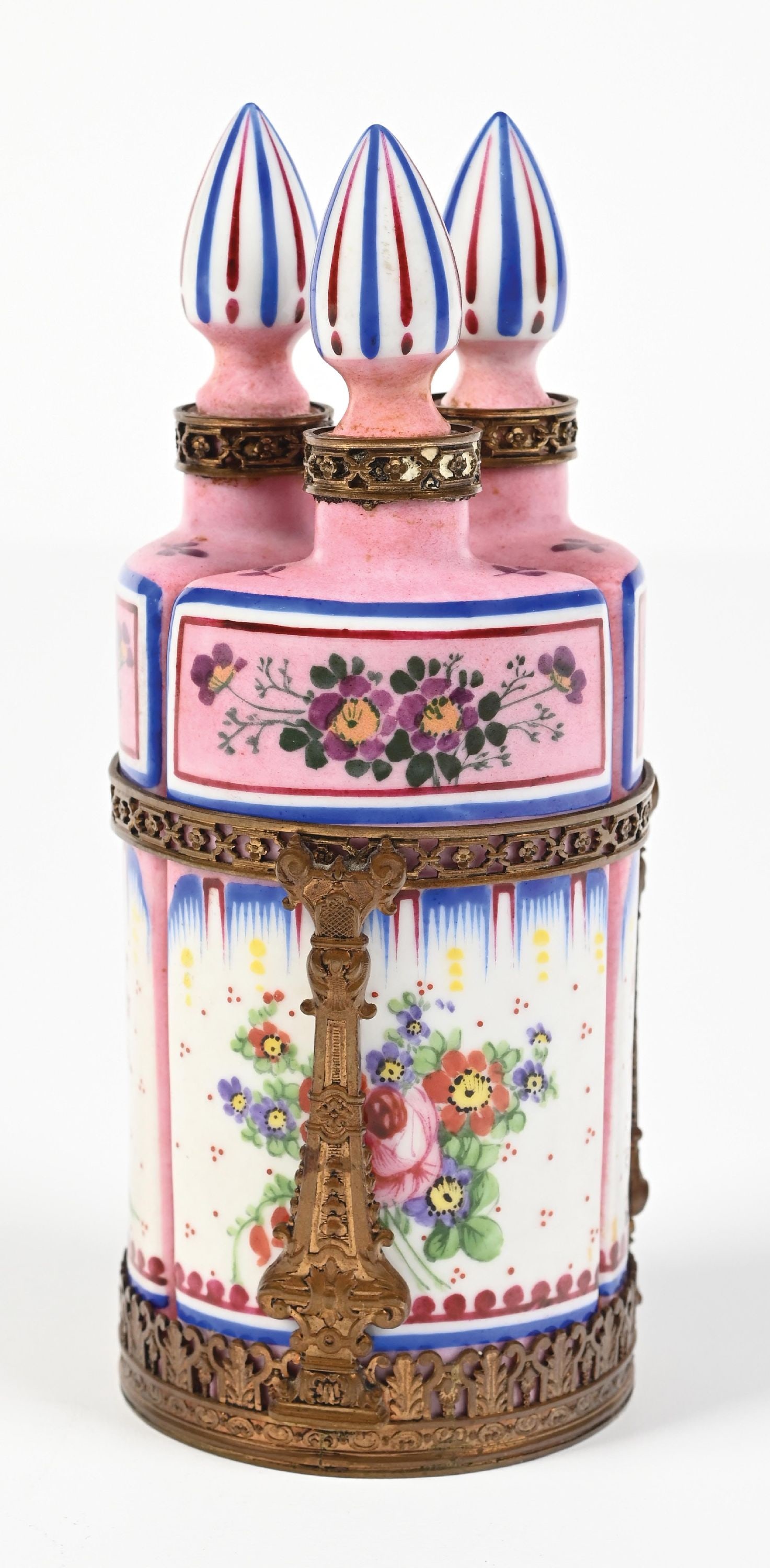 FRENCH PORCELAIN TRIPLE PERFUME BOTTLE HOLDER: C. 1900s. A lovely pink French porcelain 3-piece caddy perfume set with a gilt brass frame. The set is elaborately decorated with hand-painted floral motifs and stoppers featuring a red-and-blue strip