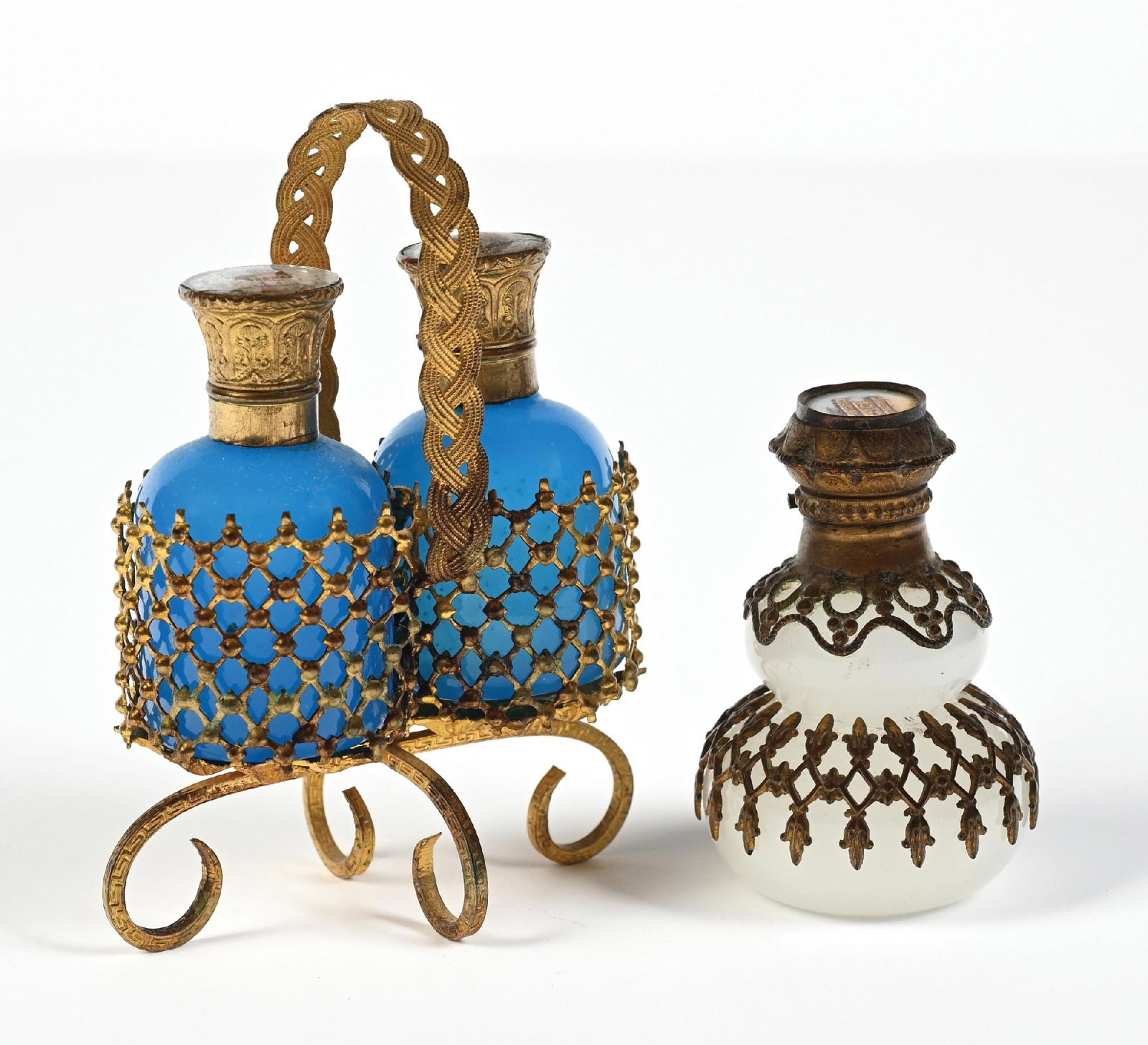 LOT OF 2: PALAIS ROYAL FRENCH OPALINE GLASS PERFUME BOTTLES: C. 1800s. (A) A lovely pair of Palais Royal blue opaline glass perfume bottles, encased in a decorative ormolu lattice-worked caddy. One of the bottles has a missing stopper, while the other bottle
