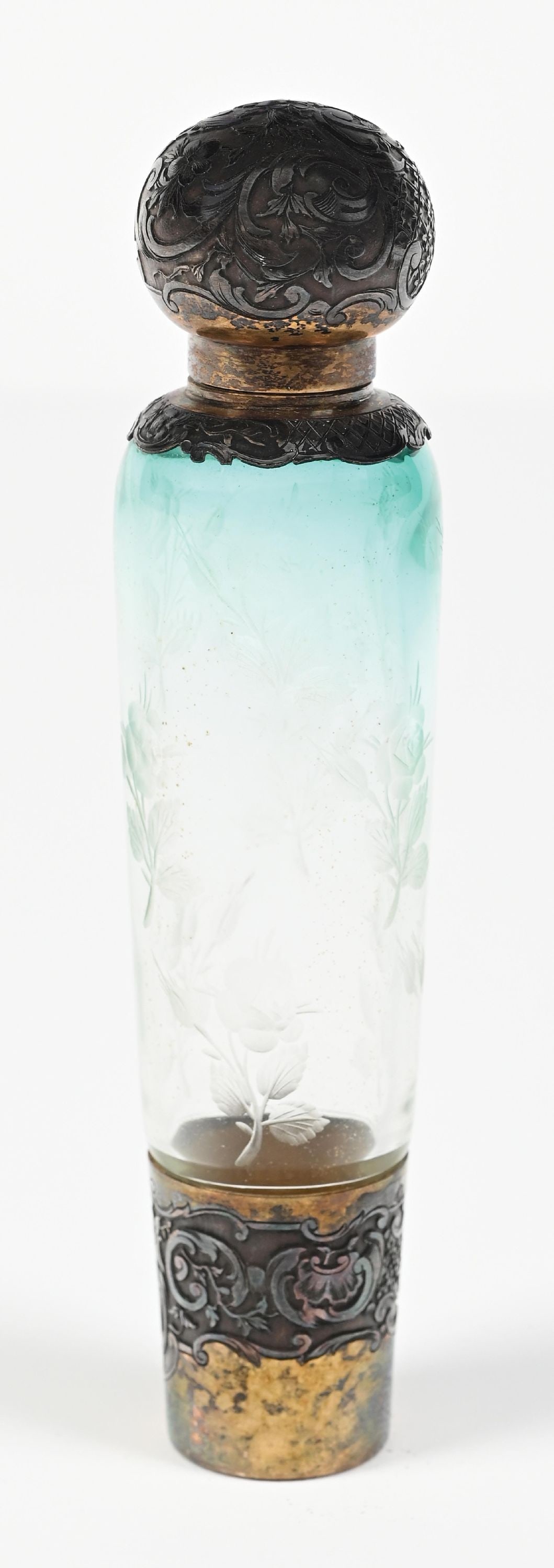 DAUM NANCY GLASS PERFUME BOTTLE: C. 1800s. A fantastic Nancy Daum scent bottle featuring ombre blue to clear acid-etched cameo glass with intricate rose patterning, the bottle has a silver and gold-toned metal screw-top lid and base,