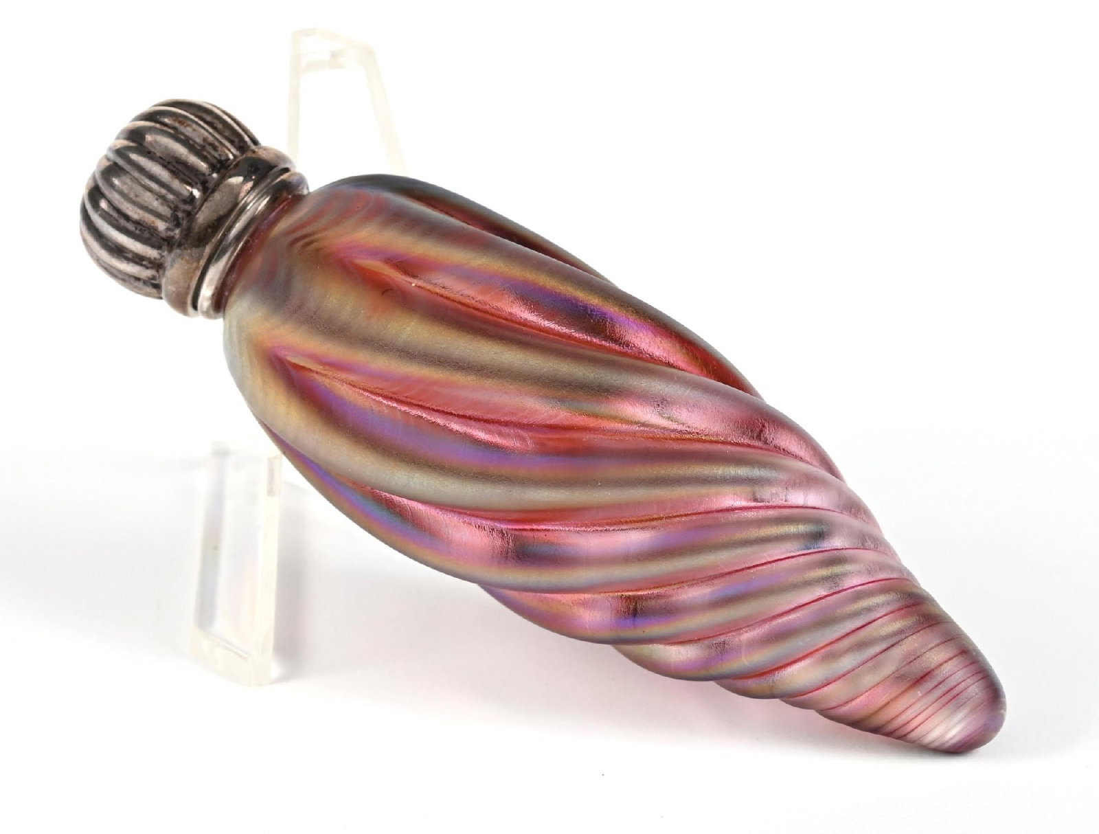 IRIDESCENT AURENE GLASS PERFUME BOTTLE: C. 1900s. An iridescent Aurene glass perfume with a decorative swirl/ribbed texture. The perfume has a sterling silver collar and lip. Silver weight: 15g. 1 - 1/2" x 4". Condition: 150 Dimensions: (Go