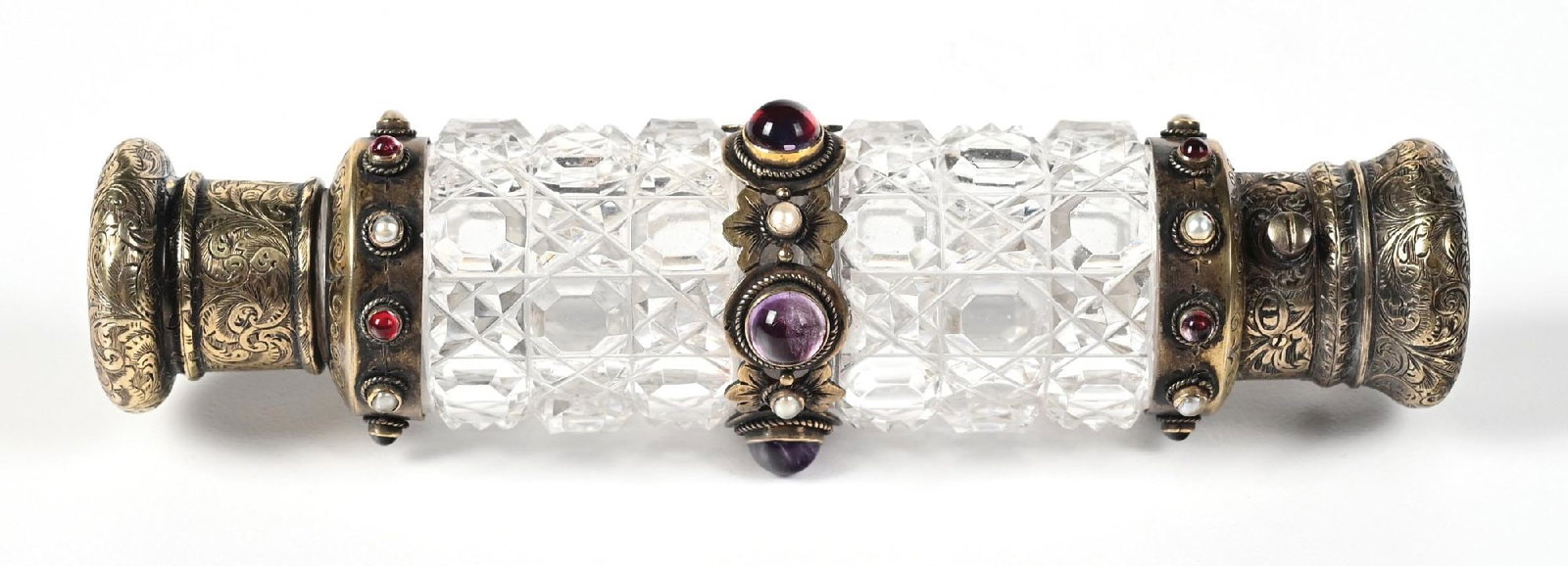 CRYSTAL DOUBLE-ENDED CUT PERFUME BOTTLE: C. 1880s. A phenomenal signed Howell & Co., London, Victorian double-ended perfume bottle with faceted-cut glass, heavily ornamented with mounted purple, red, and pearl-centered gems. The silver lids 