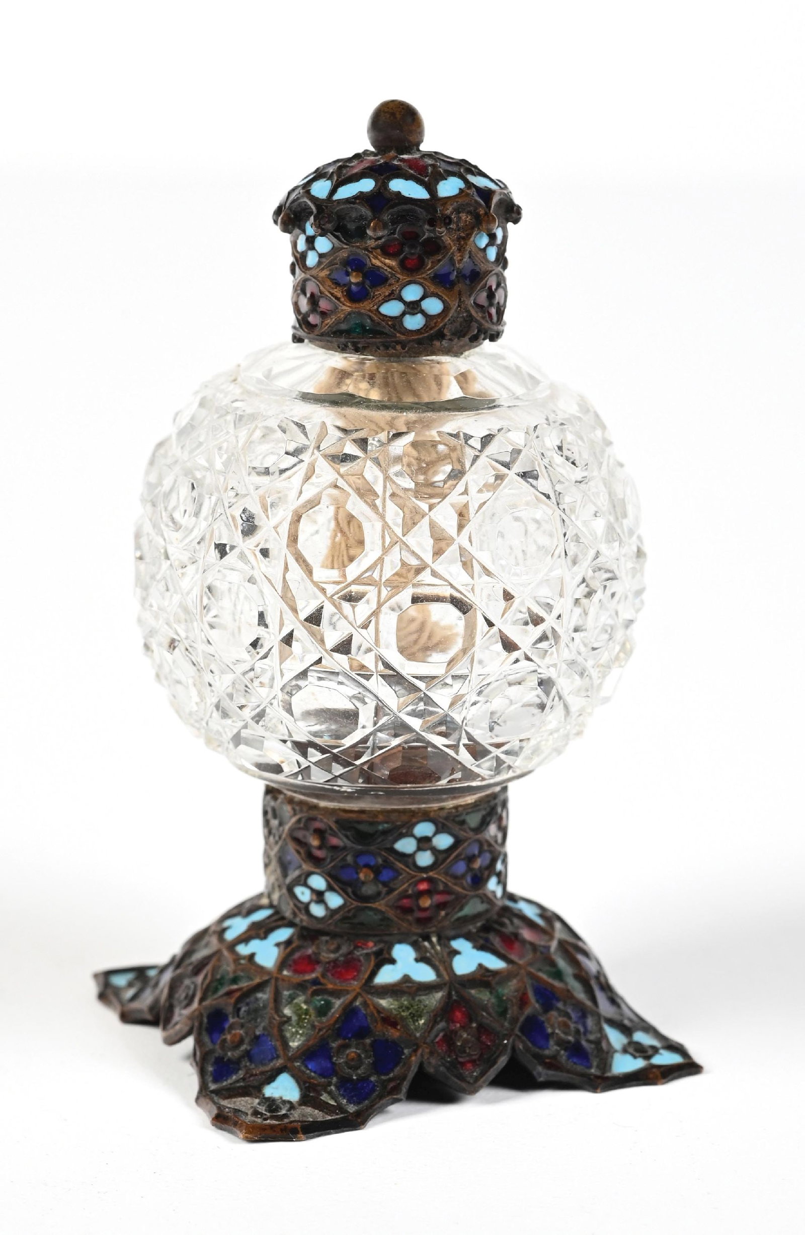 CUT GLASS PERFUME BOTTLE WITH ORNATE ENAMEL STOPPER & BASE: C. 1800s. A fantastic bulbous, clear-glass perfume with a diamond-cut pattern. The base and cap are adorned with intricate detailing and colorful enamel in shades of red, blue, turquoise, and green. T
