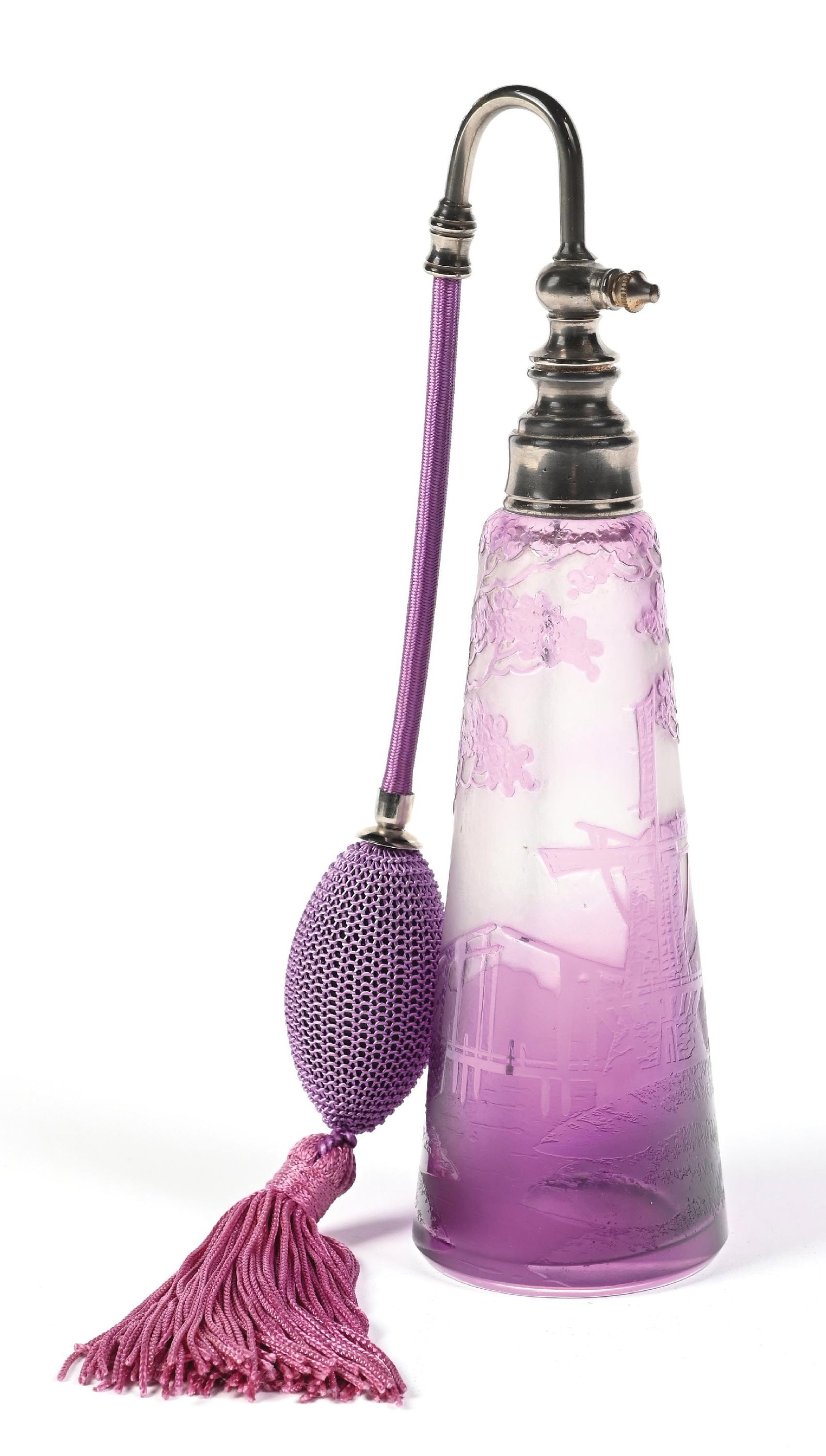 PURPLE & TRANSPARENT GRADIENT GLASS PERFUME WITH GREENERY AND WINDMILL PATTERN WITH ATOMIZER: C. 1900s. A purple ombre frosted base cameo glass perfume atomizer featuring a windmill, bridge and foliage. The perfume is complete with a purple hose and matching functional tasseled puff. The