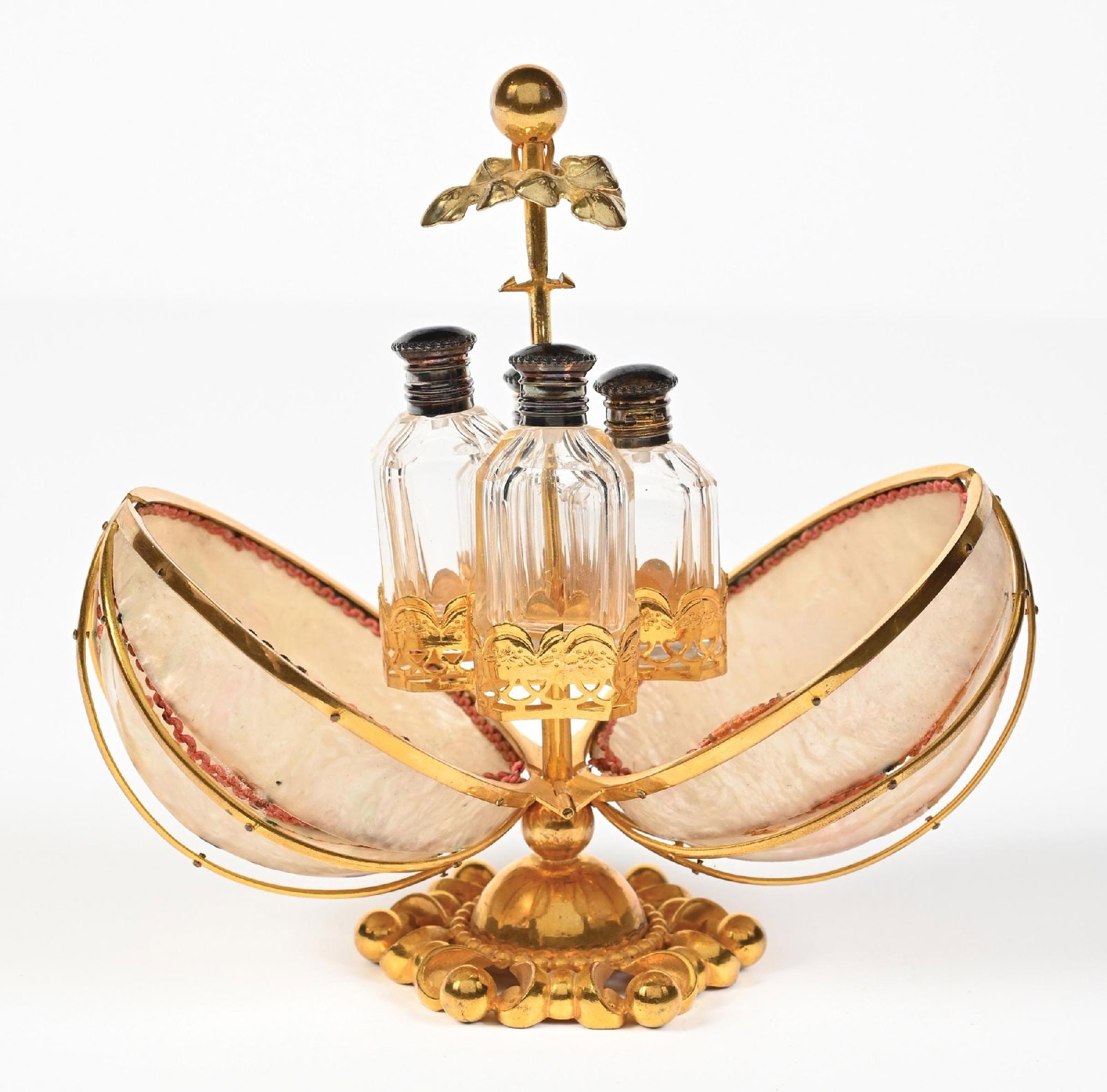 PALAIS ROYAL MOTHER OF PEARL VANITY PERFUME CASE WITH 4 PERFUME BOTTLES AND GOLD EXTERIOR CASING: C. 1800s. A marvelous French Palais Royal mechanical scent caddy. The caddy is fashioned from large mother-of-pearl shells that, when closed they form a globe-shaped casket. The central stem, featurin