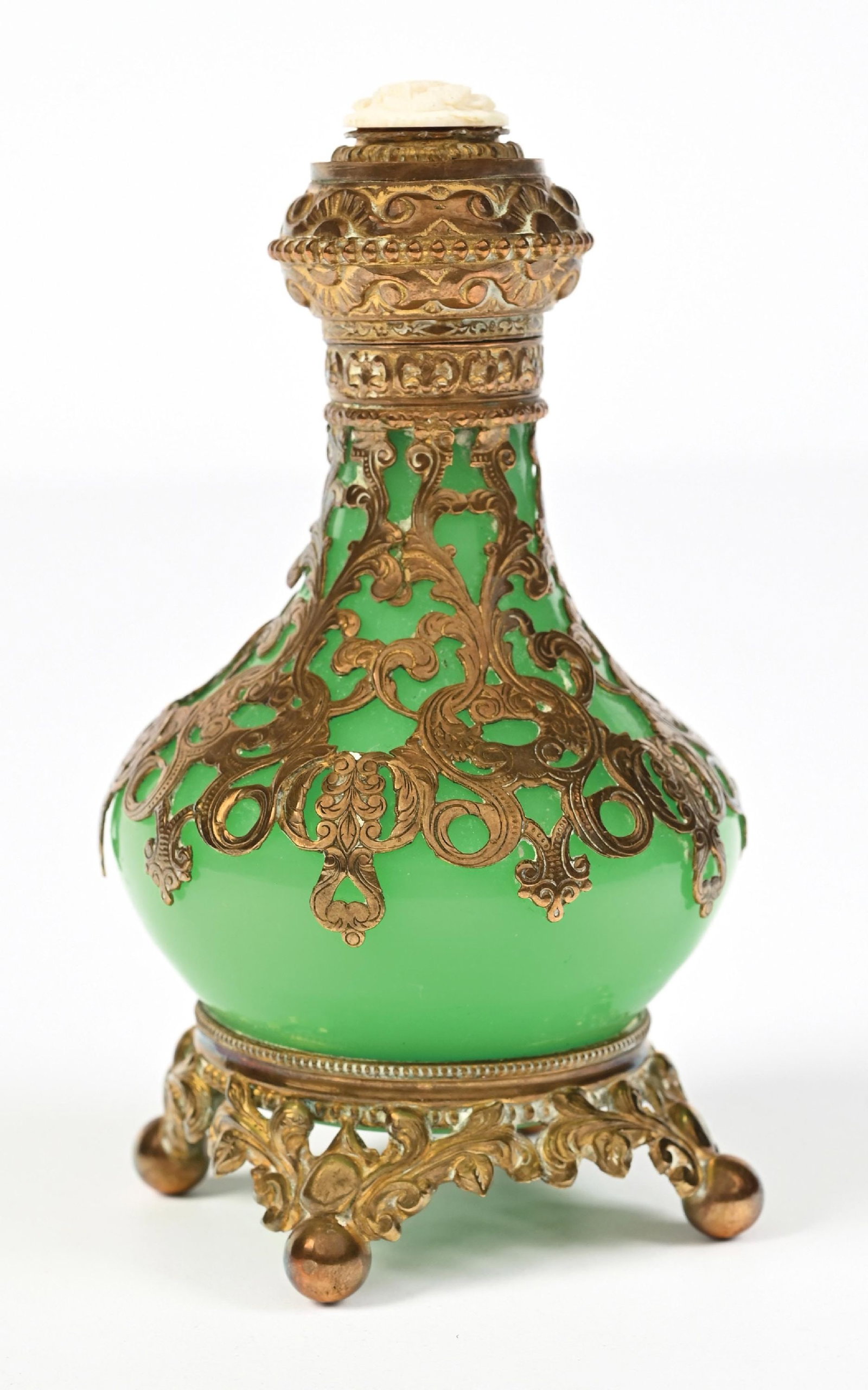 PALAIS ROYAL FRENCH GREEN OPALINE PERFUME BOTTLE: C. 1830s-1840s. A beautiful uranium French Palais Royal opaline glass perfume bottle with ornate gold-toned overlay and mounting. The hinged lid appears to be topped with a dragon, likely carved from 