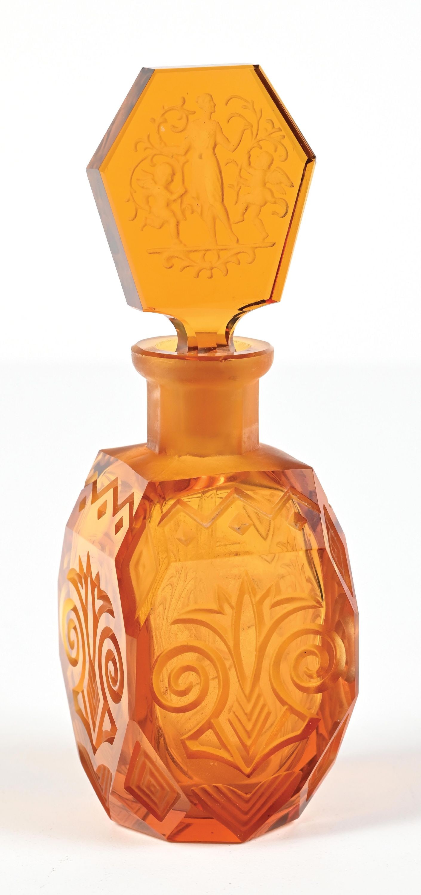 JOSEF SCHMIDT AMBER GLASS PERFUME BOTTLE: C. 1930s. A charming Art Deco Heinrich Hoffmann amber glass perfume bottle. It features a faceted, hexagonal body with a figural intaglio design depicting a nude female figure with two cherubs. There 