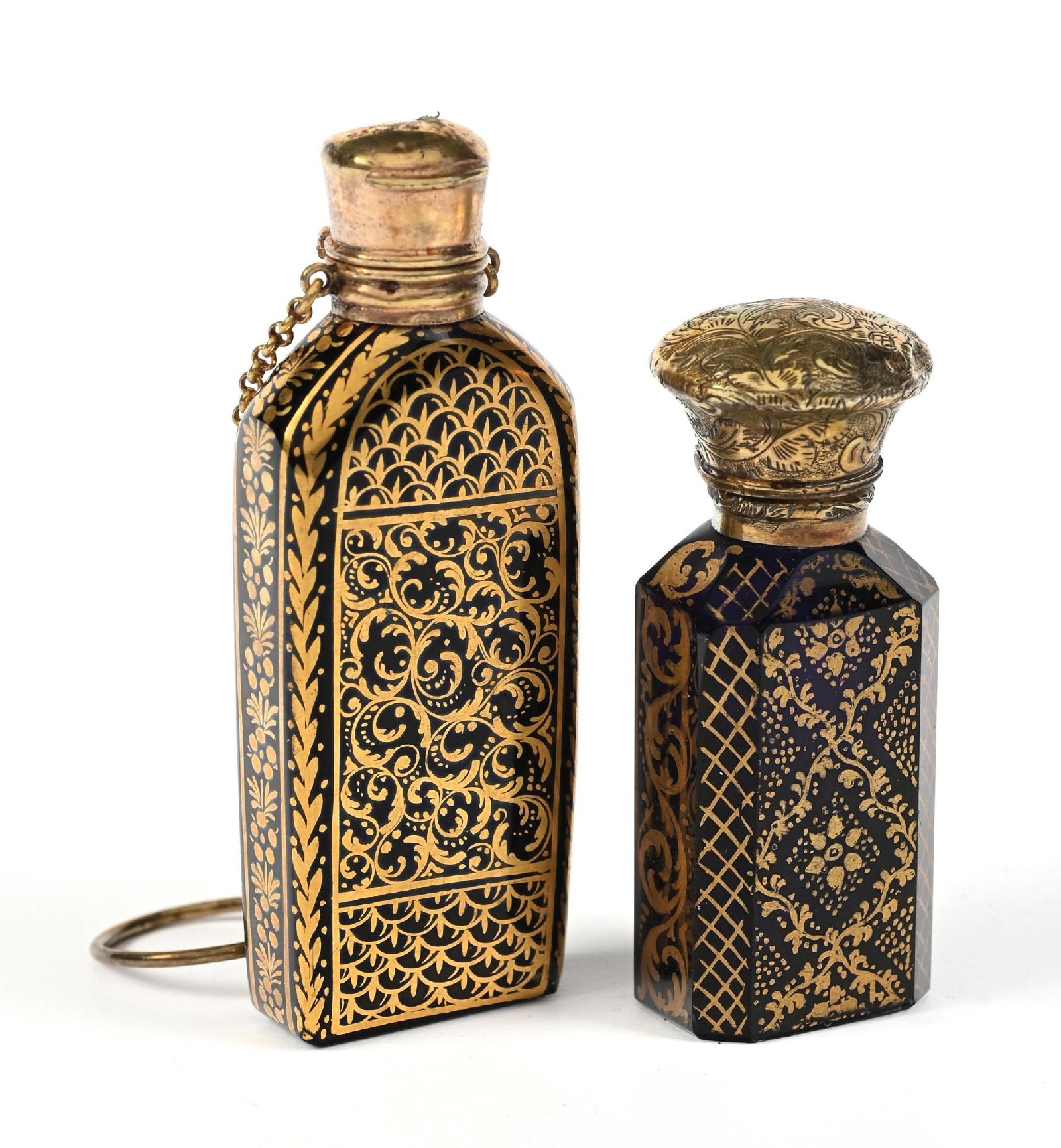 LOT OF 2: VICTORIAN CHATELAINE PERFUME BOTTLES: C. 1850s. A pair of fantastic Hyalith glass perfumes, likely bohemian, featuring extremely ornate gold-gilding. The larger bottle still has its châtelaine chain and ring; the glass stopper has br