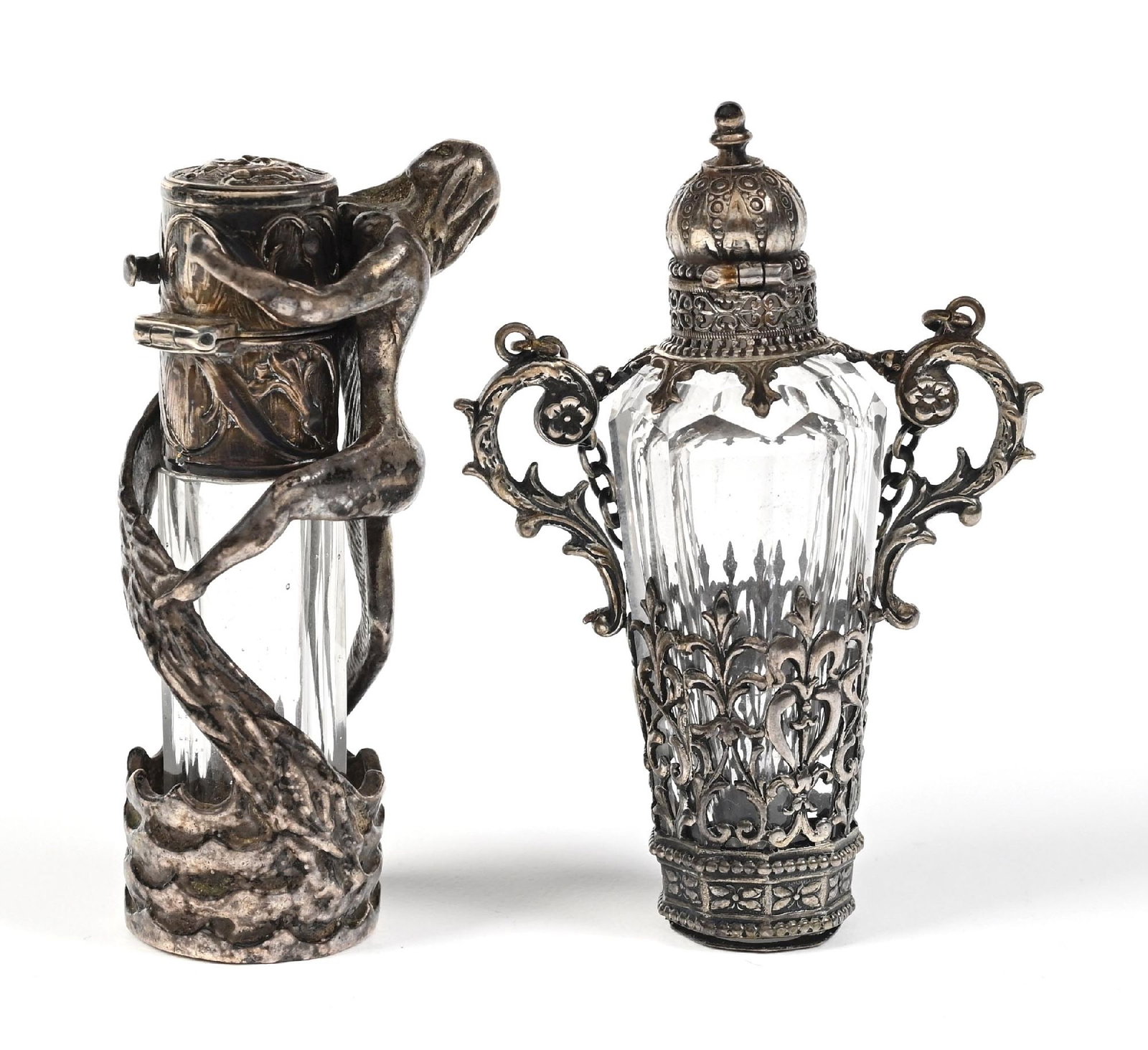 LOT OF 2: HUNGARIAN CUT CRYSTAL PERFUME BOTTLES: C. 1800. Silver, clear-cut glass perfumes, one of which is marked 800 silver, the perfumes are in good condition with a mild patina, with intricate, unique metalwork. Largest: 1" x 2 - 1/2". Condition