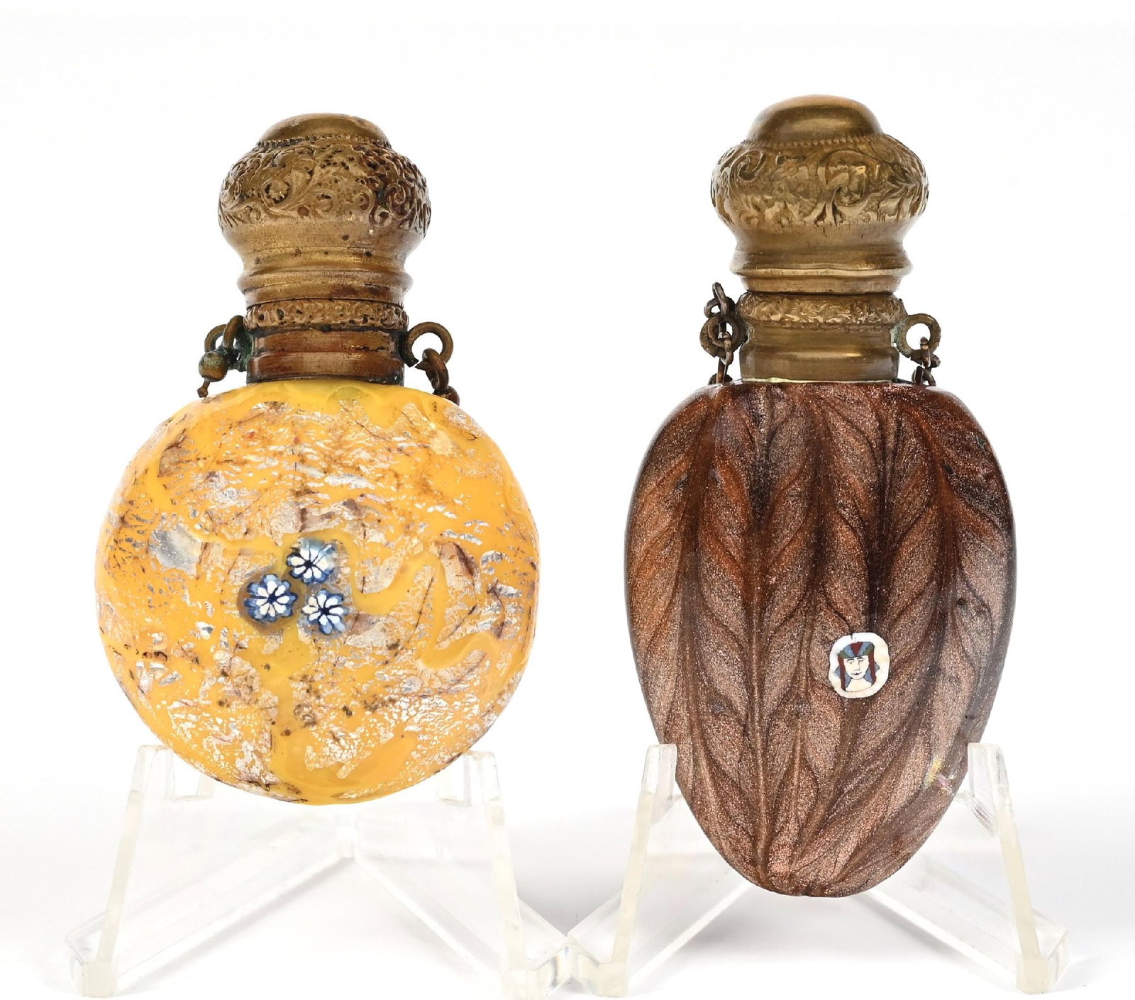 LOT OF 2: VINTAGE POLISHED DECORATIVE MURANO PERFUME BOTTLES: C. 1800s. (A) A sculpted leaf-shaped perfume featuring a Venetian Aventurine glittering and a Millefiori portrait. The perfume has gold-toned hardware and a Châtelaine chain, and a glass stopper,