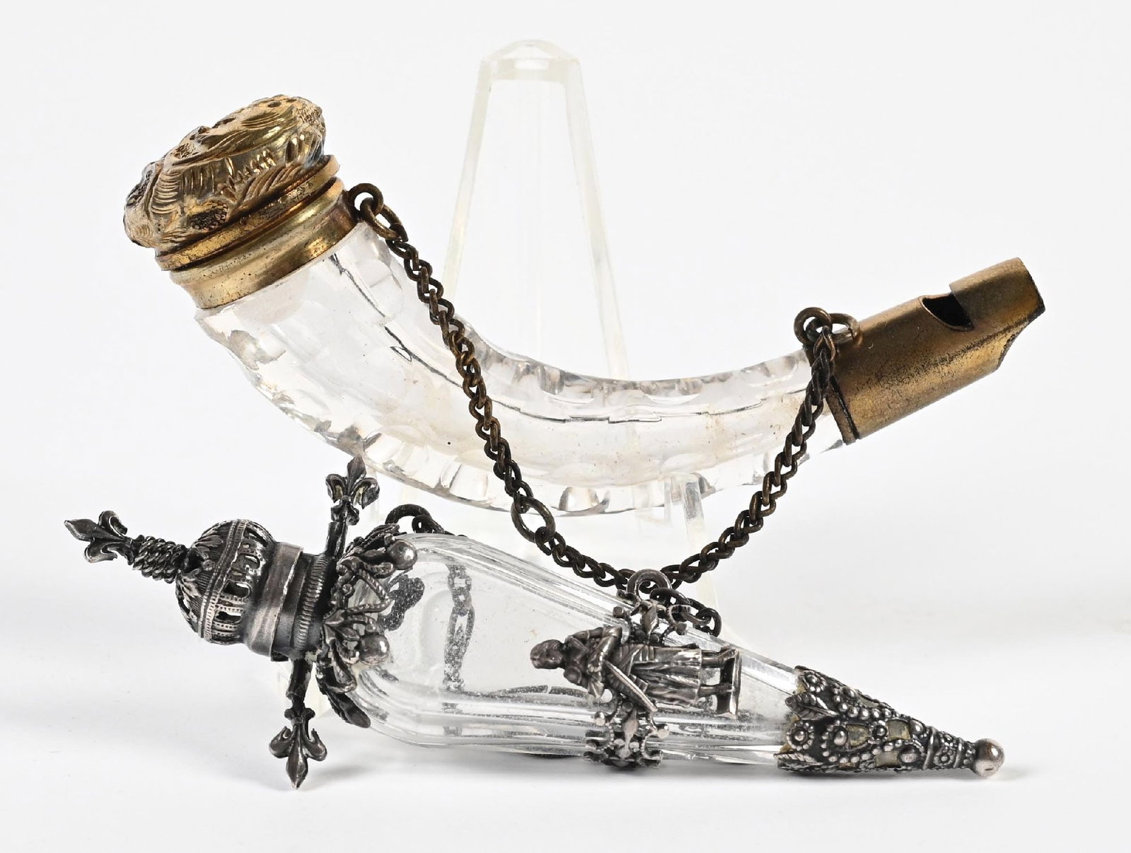 LOT OF 2: CLEAR GLASS SMALL PERFUME BOTTLES: C. 1800s. (A) A clear honeycomb-cut glass châtelaine perfume and whistle with gold-toned ornate metalwork and natural patina, in good condition. (B) A triangular, clear-cut glass châtelaine 