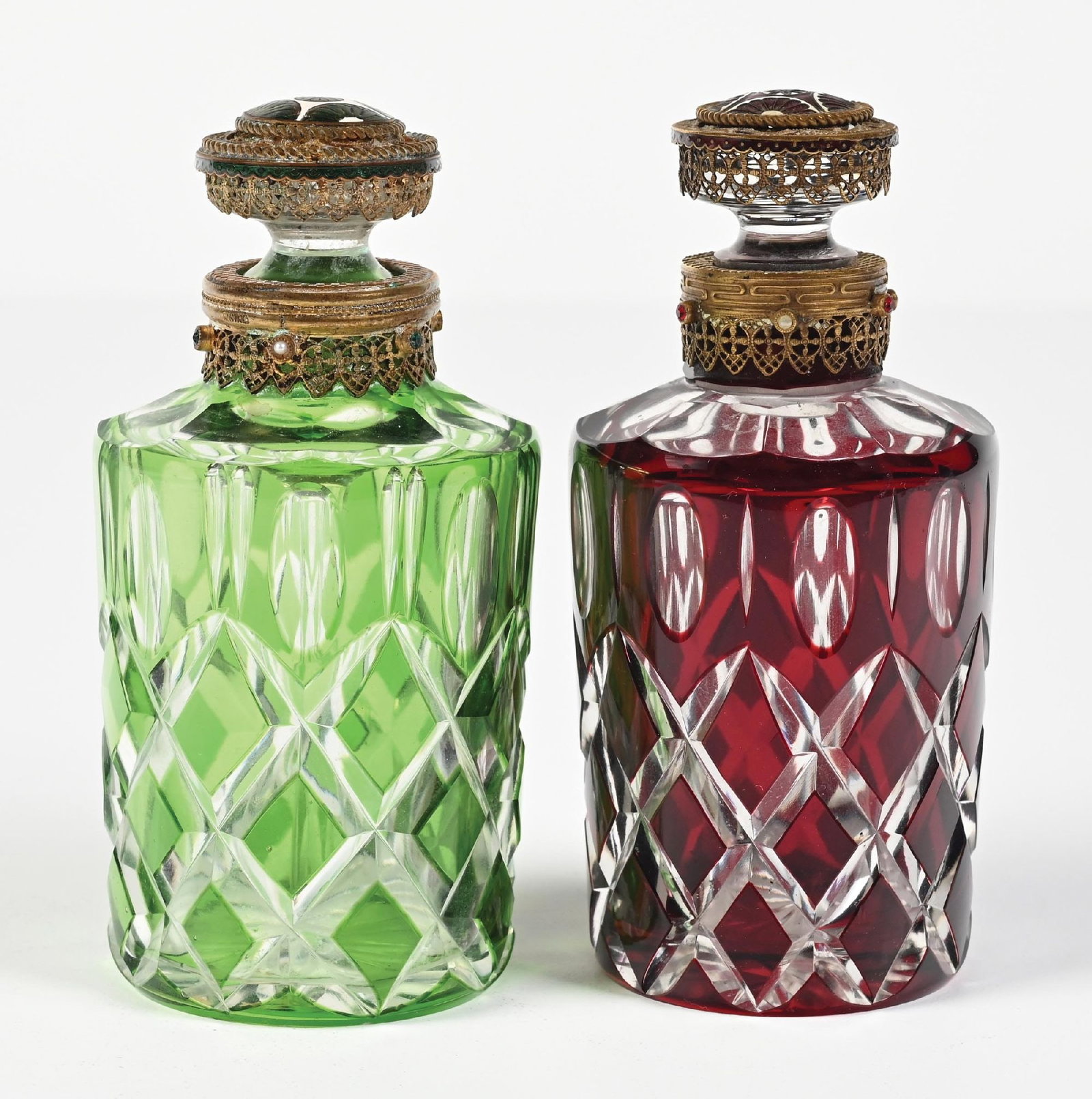 LOT OF 2: AUSTRIAN CUT GLASS PERFUMES: C. 1900s. (A) A pretty Austrian green-cut-to-clear glass perfume with a jeweled filigree topper, an enamel-topped dip tube, and pearlescent and green jewels. The perfume contains a glass dip tube that