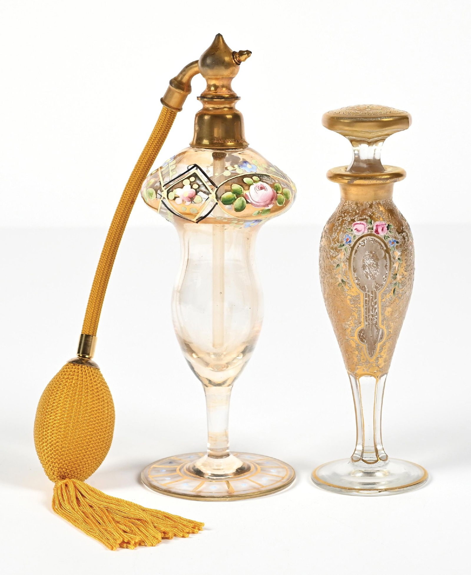 LOT OF 2: HEISEY & FRANCK IRIDESCENT GOLD TONE PERFUME BOTTLES WITH HAND-PAINTED FLOWERS: C. 1920s. (A) A beautiful, signed A.H. Heisey & Company perfume with stopper; the glass body features extensive gold-leafed decor in an "ice-chipped" pattern, with enamel floral patterns, etched windo