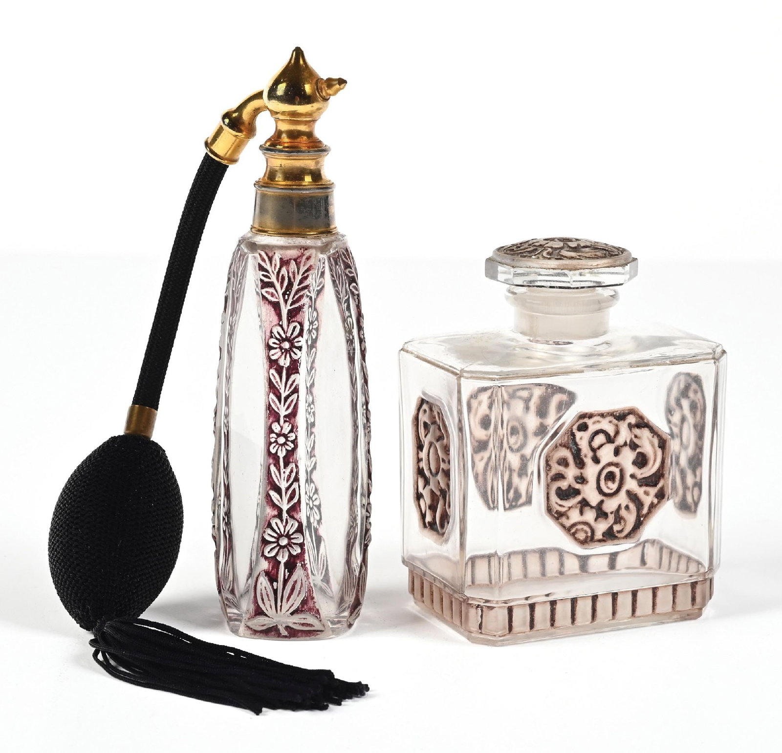 LOT OF 2: FLORAL ETCHED PERFUME ATOMIZER AND BOTTLE: C. 1920s. (A) A clear-glass perfume atomizer with maroon floral intaglio cut designs, gold-toned hardware. The perfume has a back hose and a functional tasseled matching puff. Honest wear consistent w