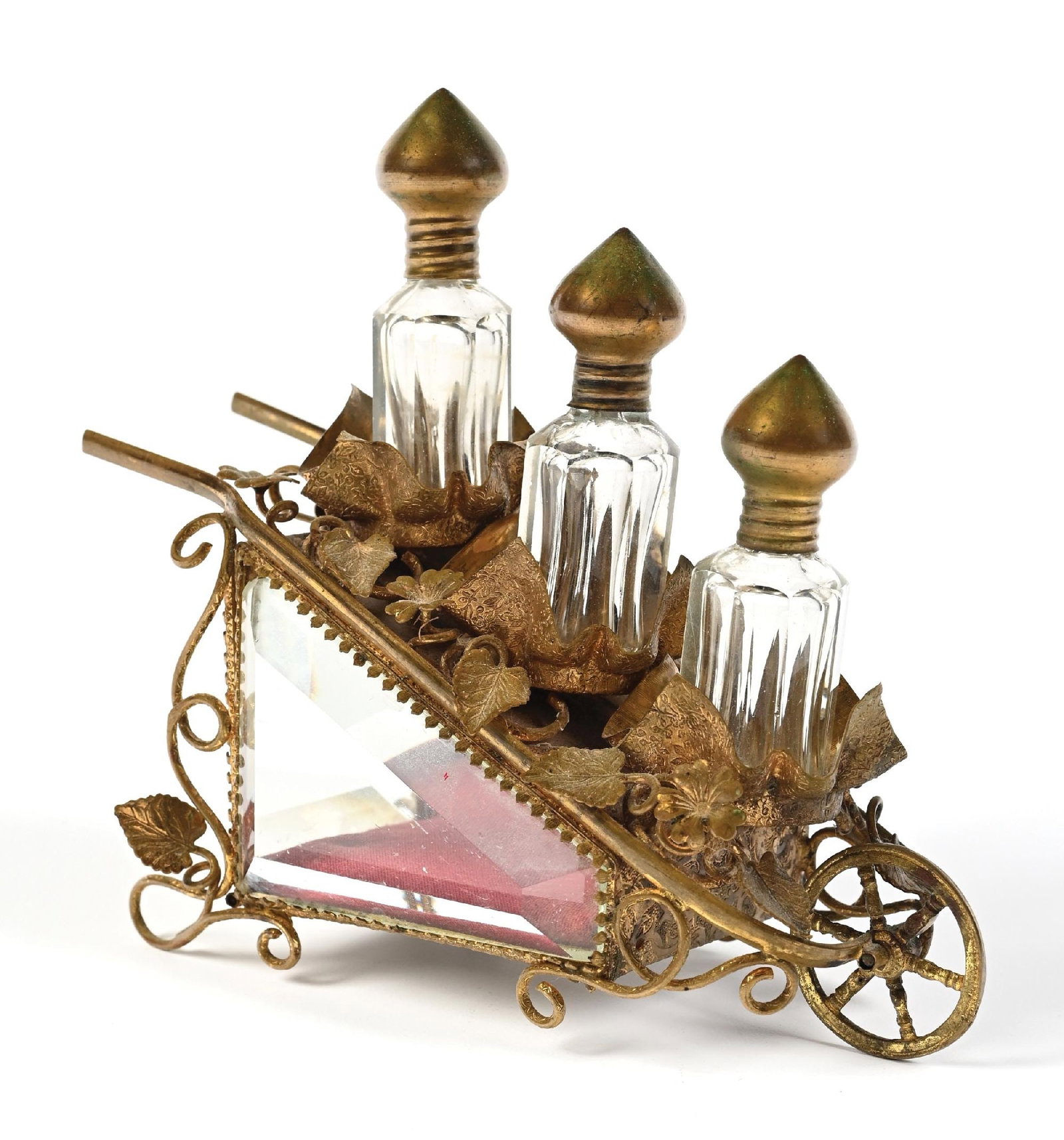 3 PERFUMES IN AN ORNATE GILDED METAL HOLDER WITH WHEEL: C. 1800s. A spectacular French perfume scent caddy, designed as a functional wheelbarrow, made of patinaed brass, featuring intricate floral and foliage patterns, including grapevines and small flower