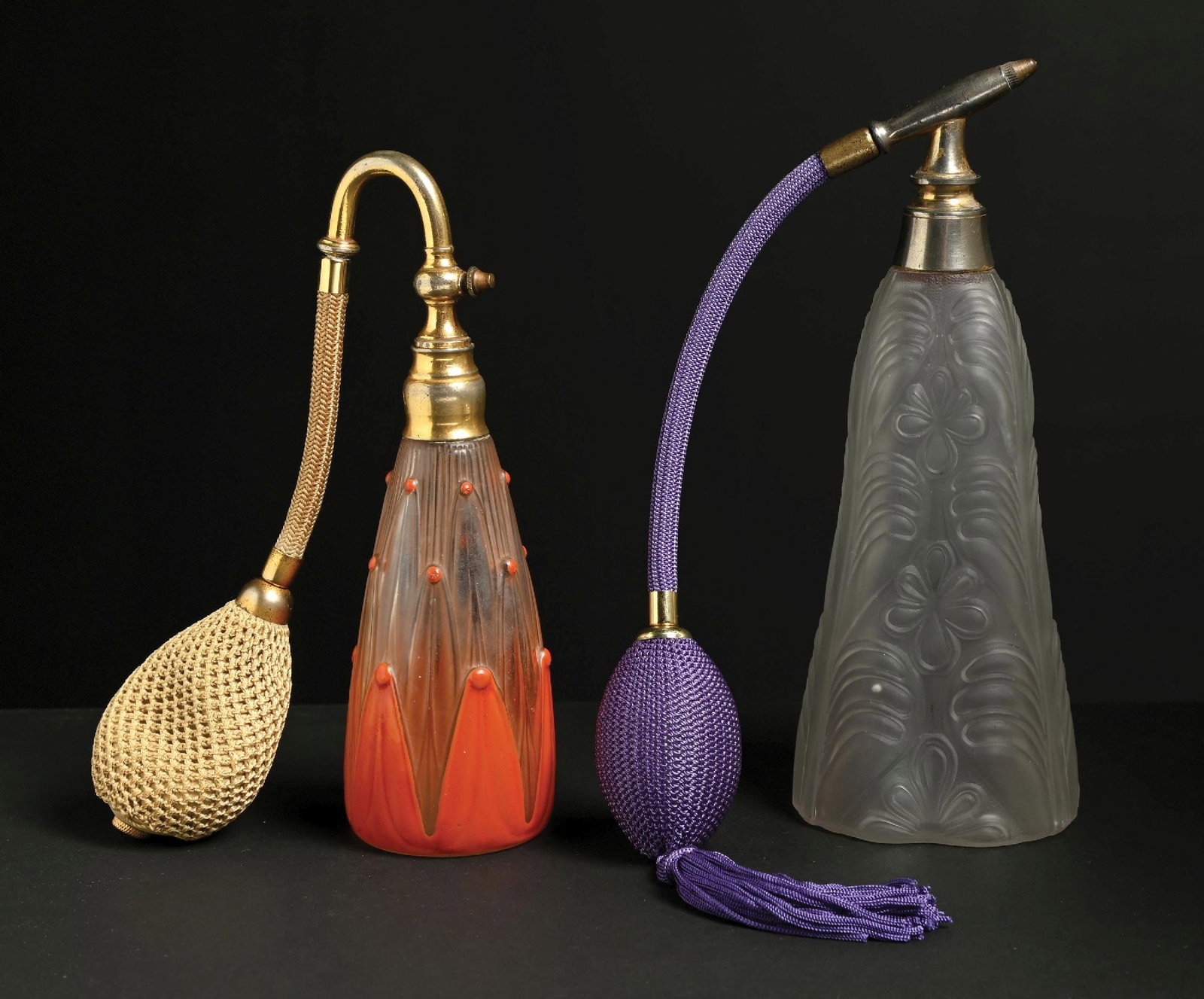 LOT OF 2: VIARD ENAMEL ART DECO PERFUME ATOMIZER, & FROSTED FRENCH PERFUME ATOMIZER: C. 1920s. (A) A great French Viard perfume with an orange enamel exterior and a clear faceted glass shape. It has gold-metal hardware, a tan hose, and a hard atomizer puff. The glass is in great condi