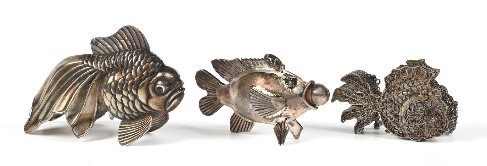 LOT OF 3: SILVER SMALL FISH PERFUMES: C. 1800s. A collection of three silver fish perfumes. One of the fish is marked sterling silver and weighs 18.38 grams; the filigree fish is likely sterling silver and weighs 7.47 grams. The largest f