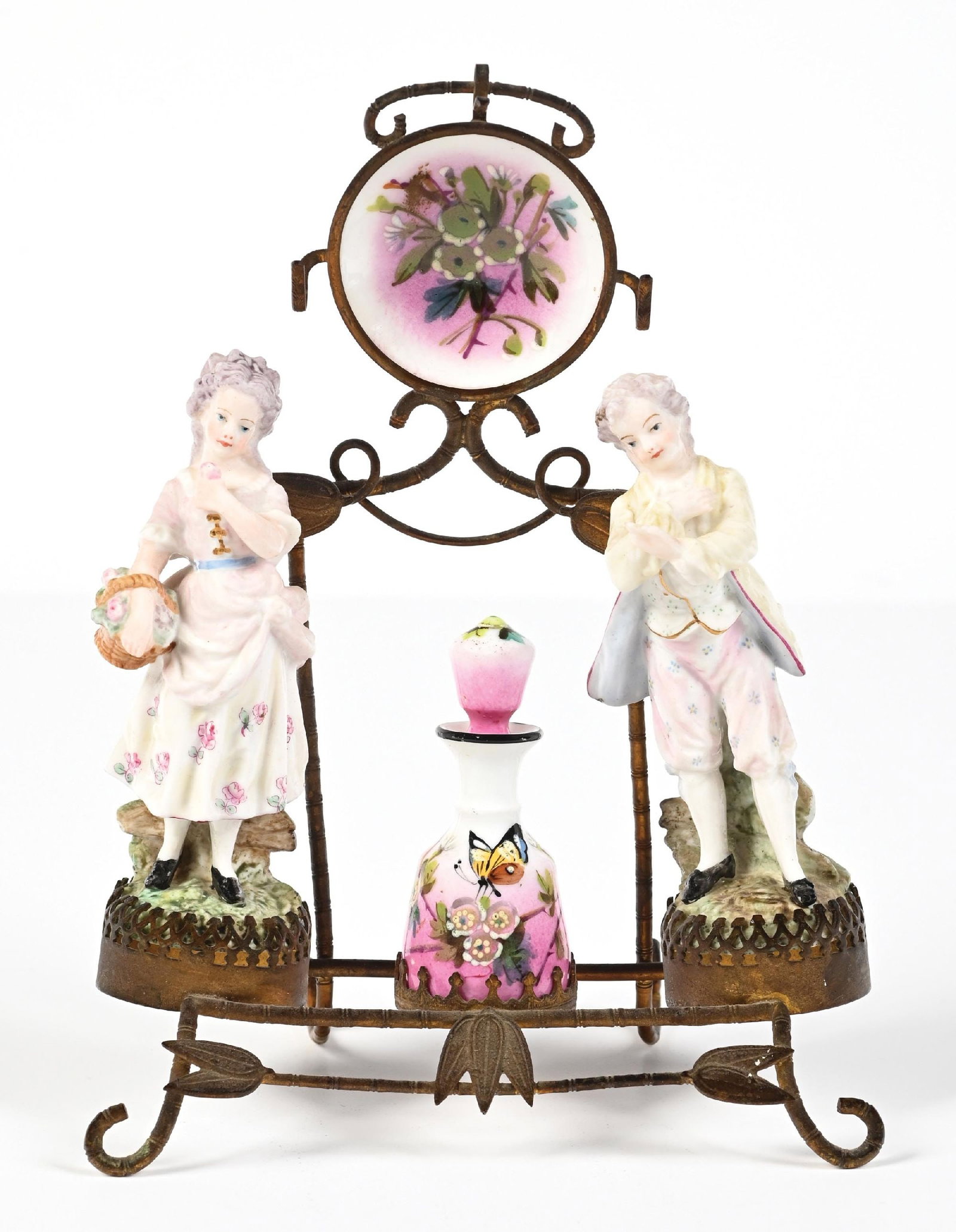 PORCELAIN FIGURAL DRESSING TABLE SET WITH FLORAL PATTERN: C. 1800s. A Meissen porcelain (unmarked) perfume vanity set. The vanity set is mounted on a brass stand and features two porcelain figures of a man and woman. The vanity set also features a circular p