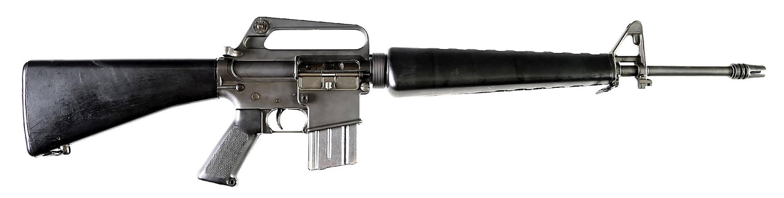 (C) EARLY COLT SP1 AR-15 SEMI-AUTOMATIC RIFLE (1967).: Manufactured in 1967. Parkerized pencil barrel marked with "S 12" twist rate and "MP" proof. Iconic 3-prong duck bill flash hider. Protected post front sight on a triangle base with bayonet lug. Carry