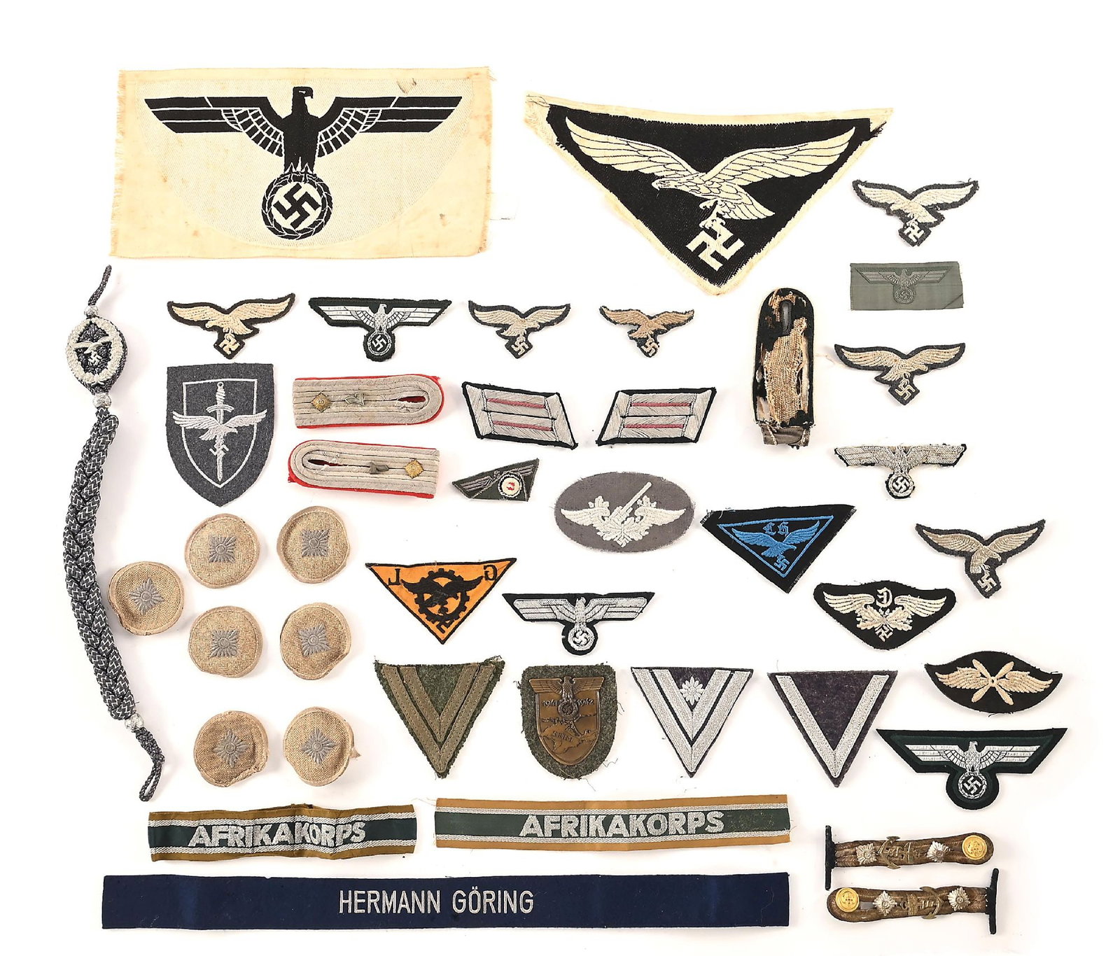 LOT OF GERMAN WWII HEER AND LUFTWAFFE INSIGNIA.: Large lot of German WWII Luftwaffe and Heer insignia. Lot includes a late war "HG Division" (Hermann Goering) cuff title, "Afrika Korps" cuff titles (1 shortened and another uniform removed), pair of 