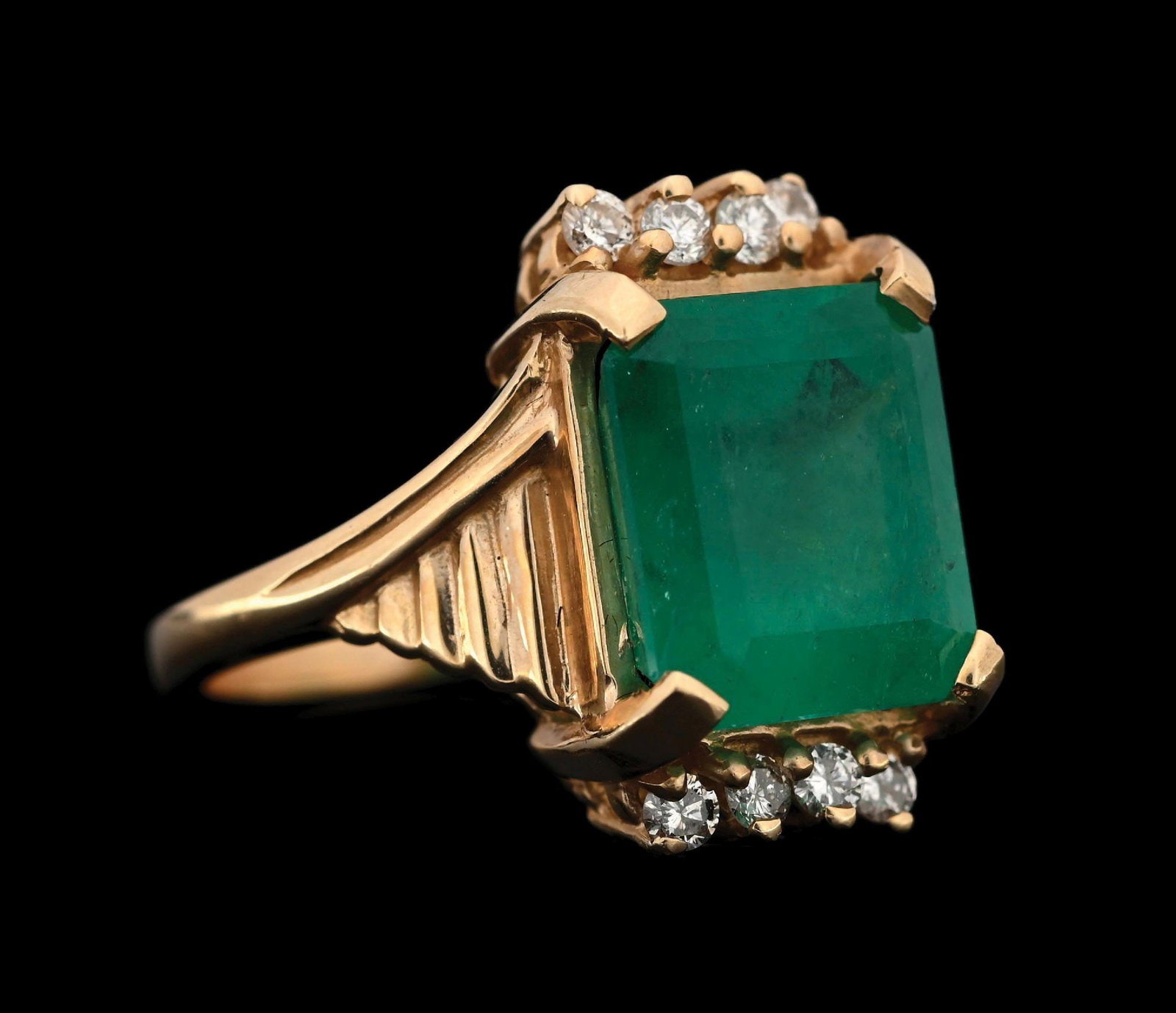 14K YELLOW GOLD COLUMBIAN EMERALD & DIAMOND RING: 14k yellow gold Columbian emerald and diamond ring consisting of 1 emerald cut emerald weighing 5.20cts and 8 round brilliant cut natural diamonds with a total weight of 0.24cts. Width at top measures