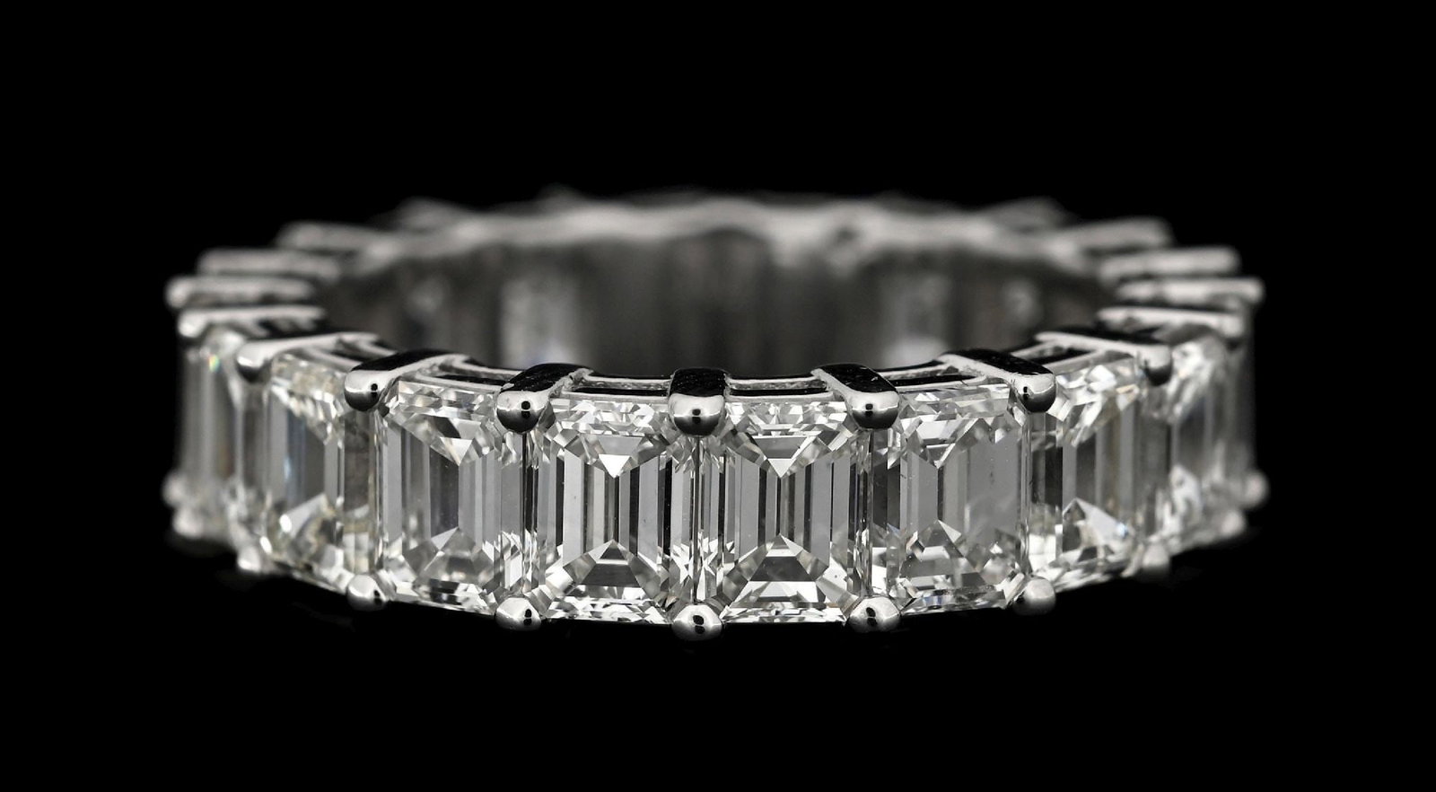 PLATINUM EMERALD CUT DIAMOND ETERNITY BAND, 6.46CT TW: Platinum diamond eternity band consisting of 20 emerald cut near-colorless natural diamonds with a total weight of 6.46cts. Width measures 5mm. Finger size 6-1/4. Gross weight is 7.0 grams. Marked "D6