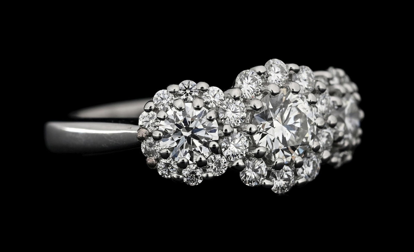 18K WHITE GOLD HEARTS ON FIRE 1.95CT TW DIAMOND RING: 18k white gold Hearts on Fire diamond ring consisting of 3 round brilliant cut natural diamonds with a combined weight of 1.20cts and another 26 round brilliant cut natural side diamonds with a total 