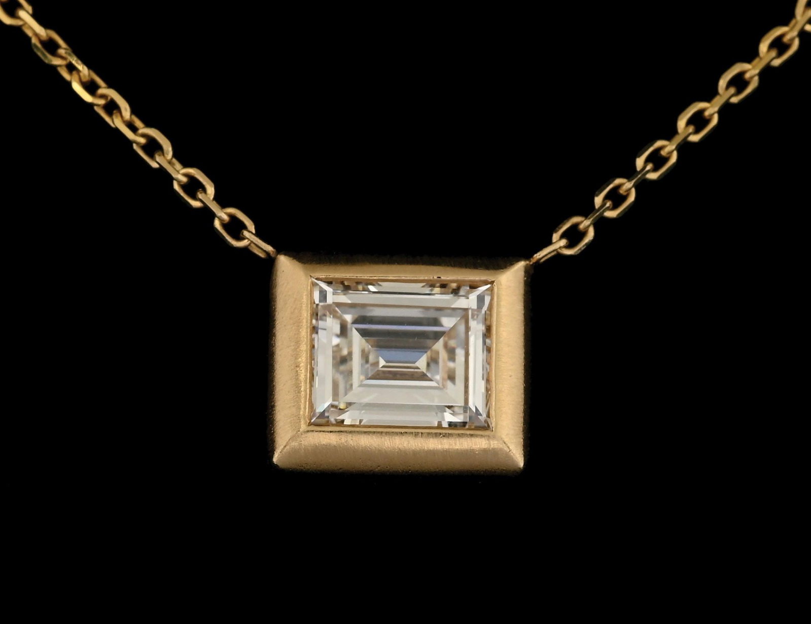 14K YELLOW GOLD 1.37CT DIAMOND SOLITAIRE NECKLACE: 14k yellow gold diamond solitaire necklace with 1 bezel-set baguette cut natural diamond weighing of 1.37cts. Length measures 16". Bezel width measures 10.5mm. Gross weight is 4.1 grams. Marked "14K".